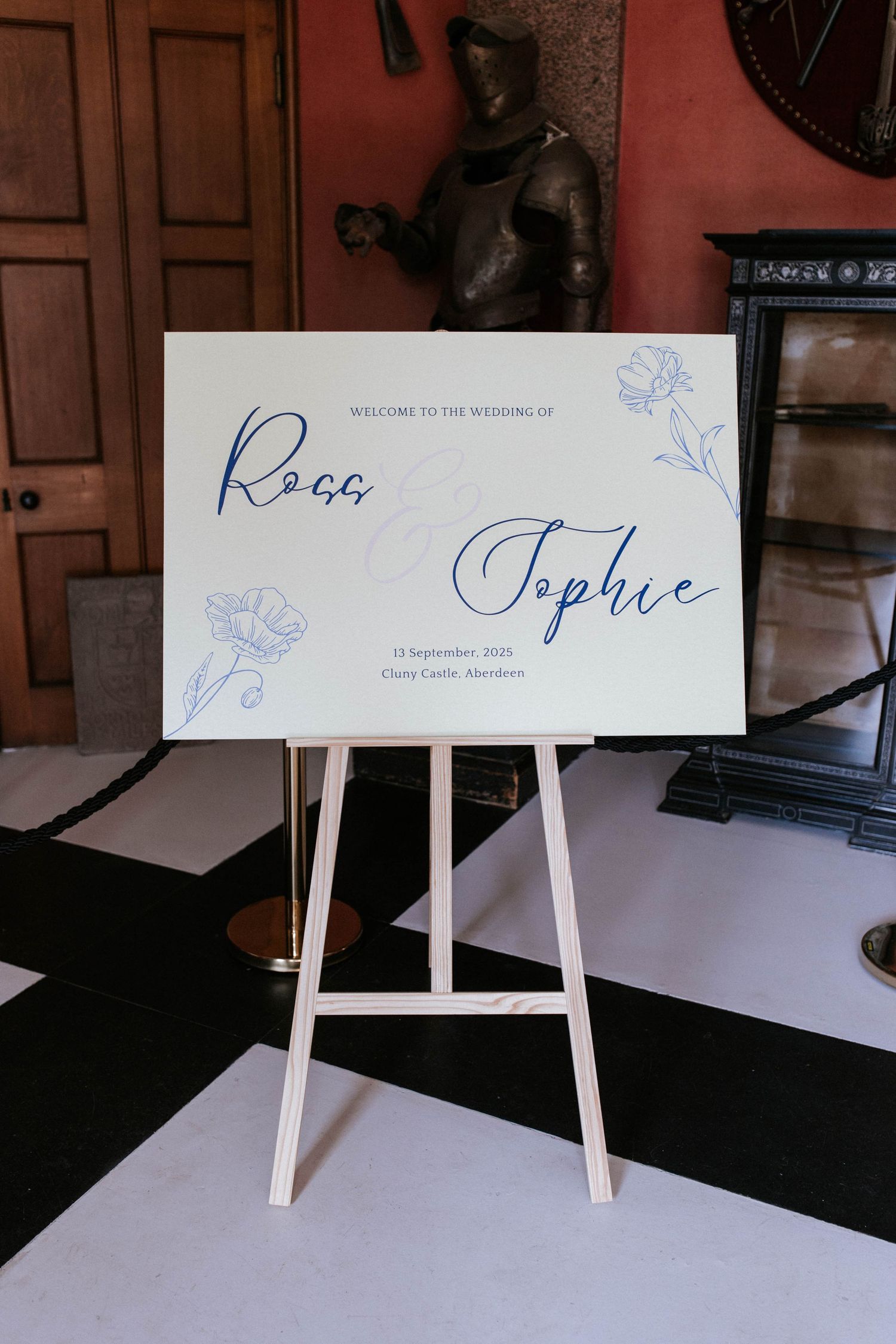 Wedding reception signage displayed on white easels with elegant blue calligraphy.