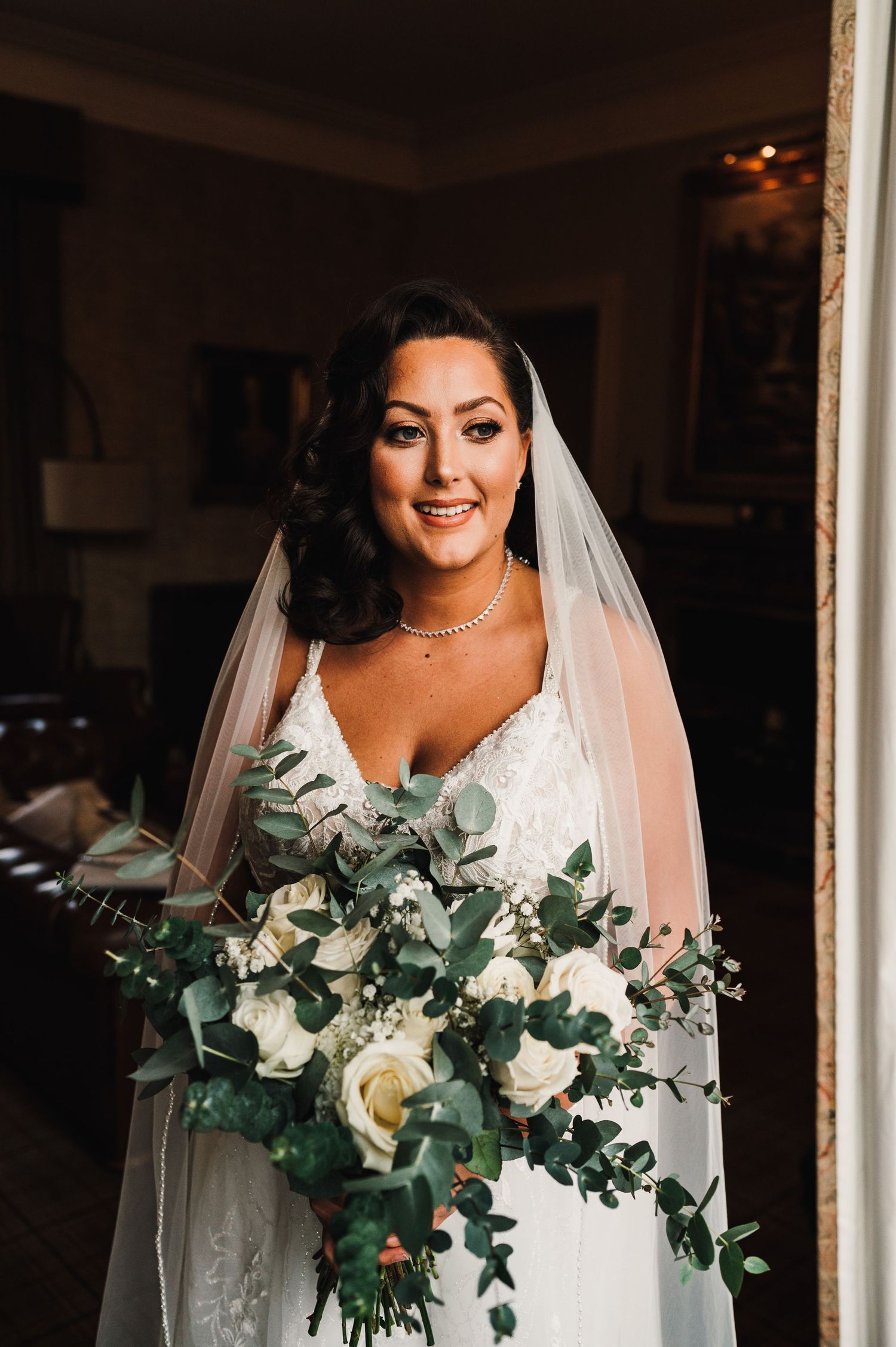 Aberdeen Wedding Photography. Elegant bridal portrait featuring a white wedding dress and lush greenery bouquet.