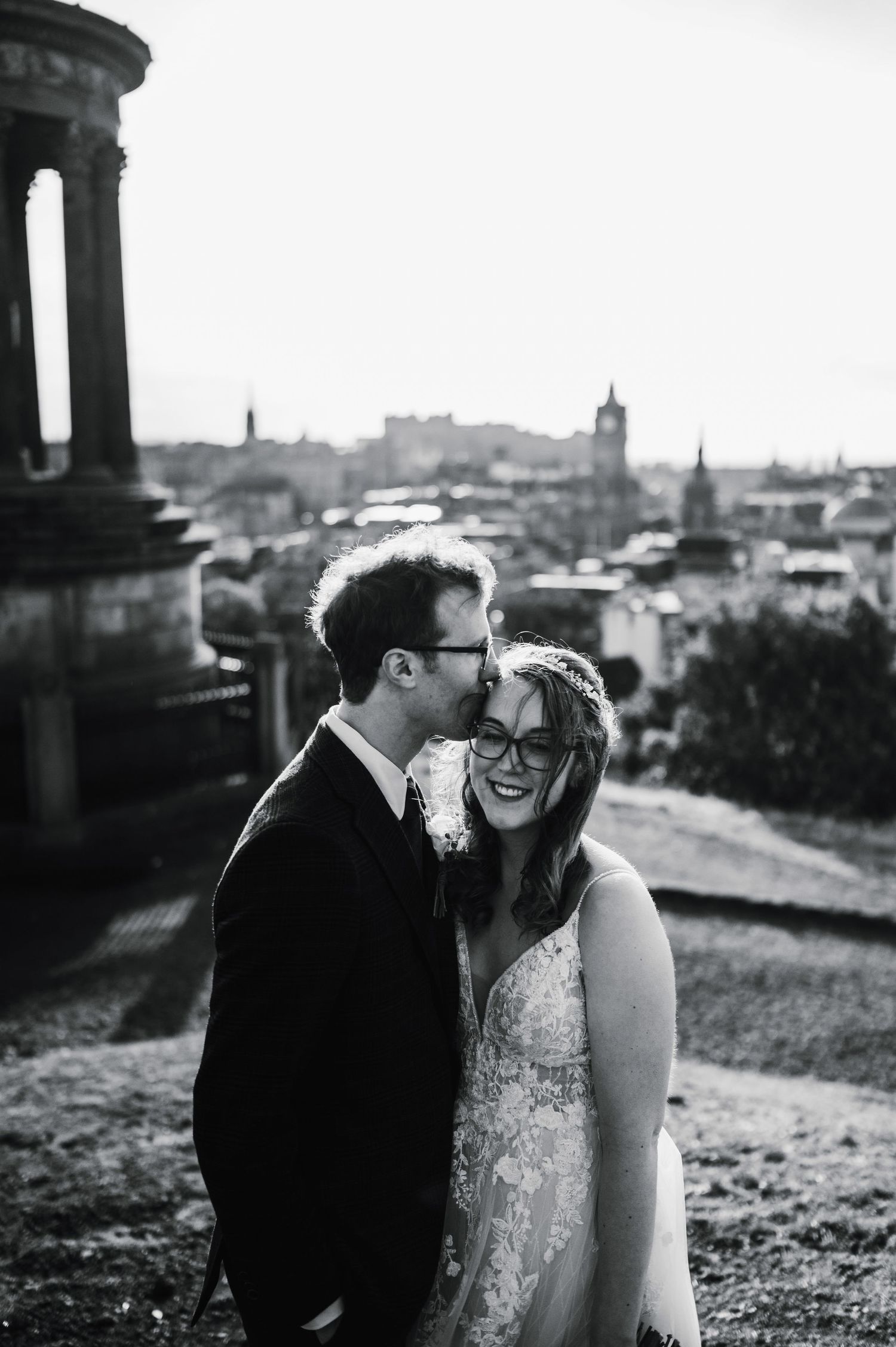 Aberdeen Wedding Photography. A black and white wedding portrait captures a joyful moment against a cityscape backdrop.