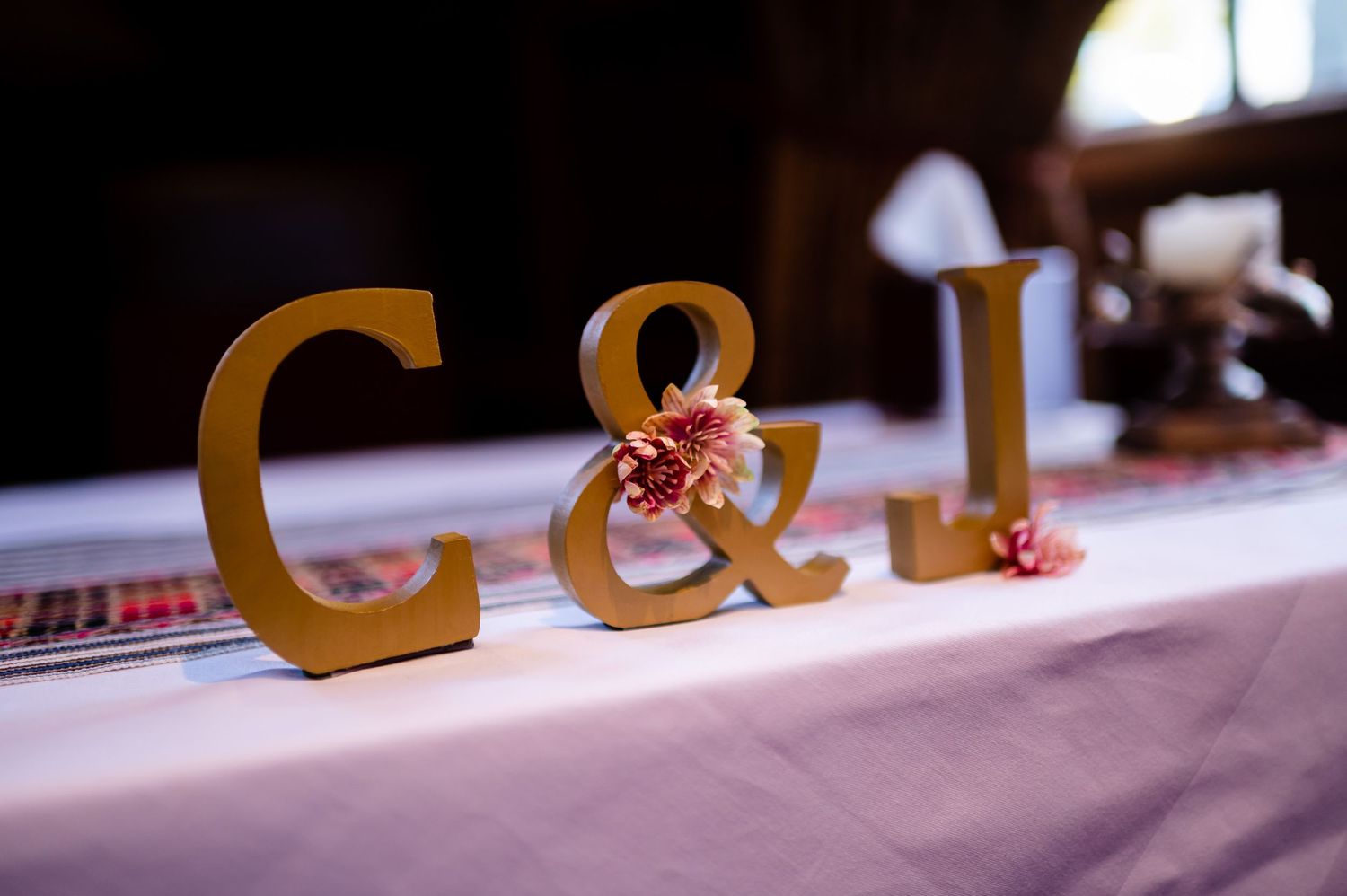Gold decorative letters C and I displayed on white tablecloth.