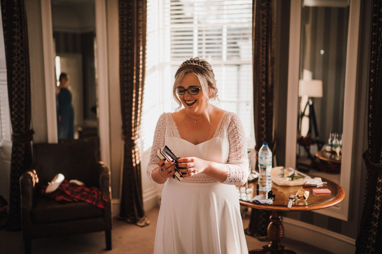 Wedding preparation scene in an elegant room with vintage furniture and natural lighting.