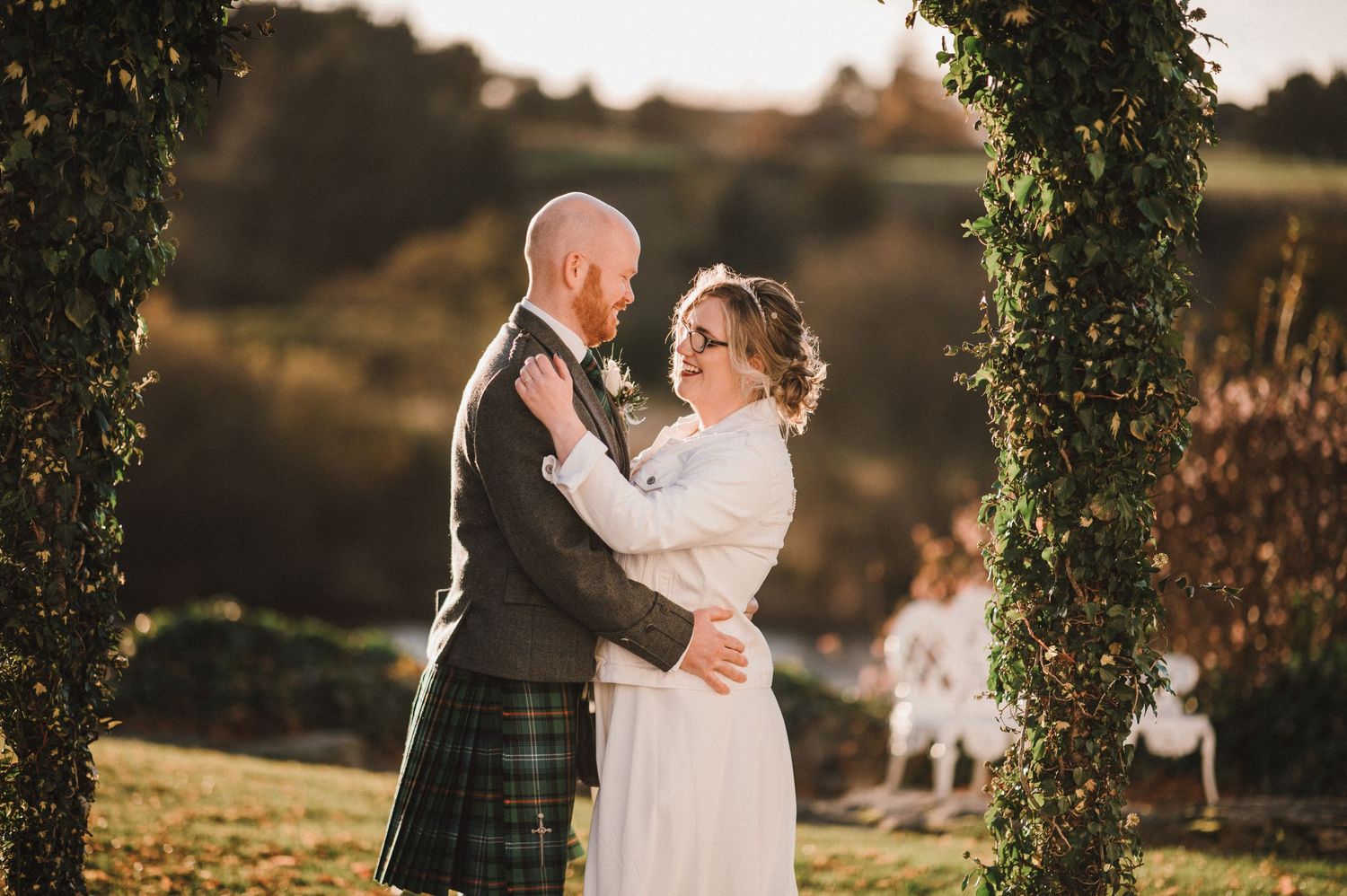 Intimate wedding moment captured under a tree with Scottish Highland dress.