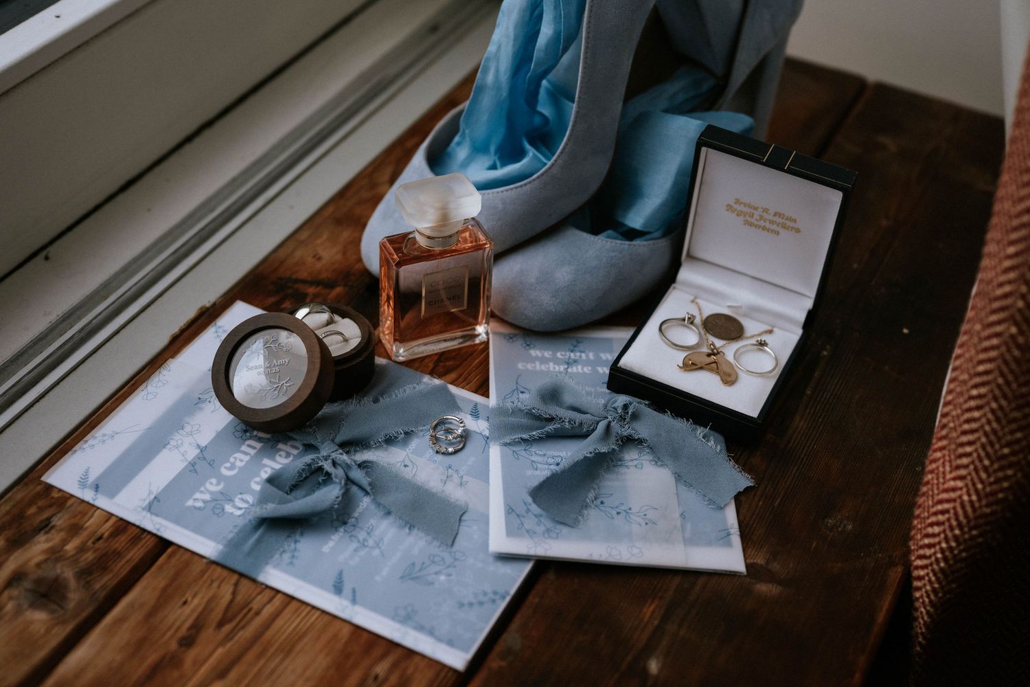 Close-up of hands signing wedding documents on a wooden surface.