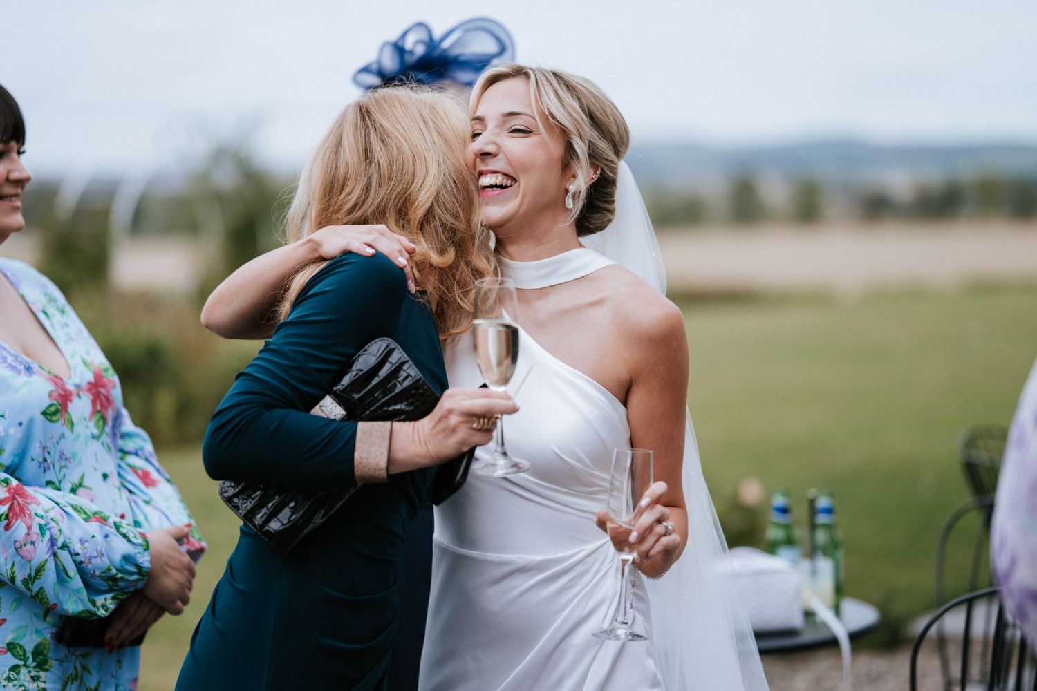 Joyful celebration and hugs shared during outdoor wedding reception festivities.