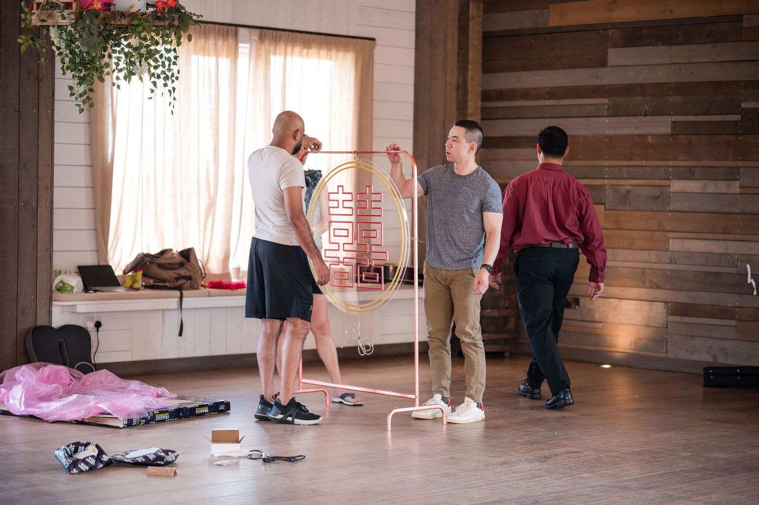 People practicing yoga poses in a rustic studio space with wooden walls and natural lighting.