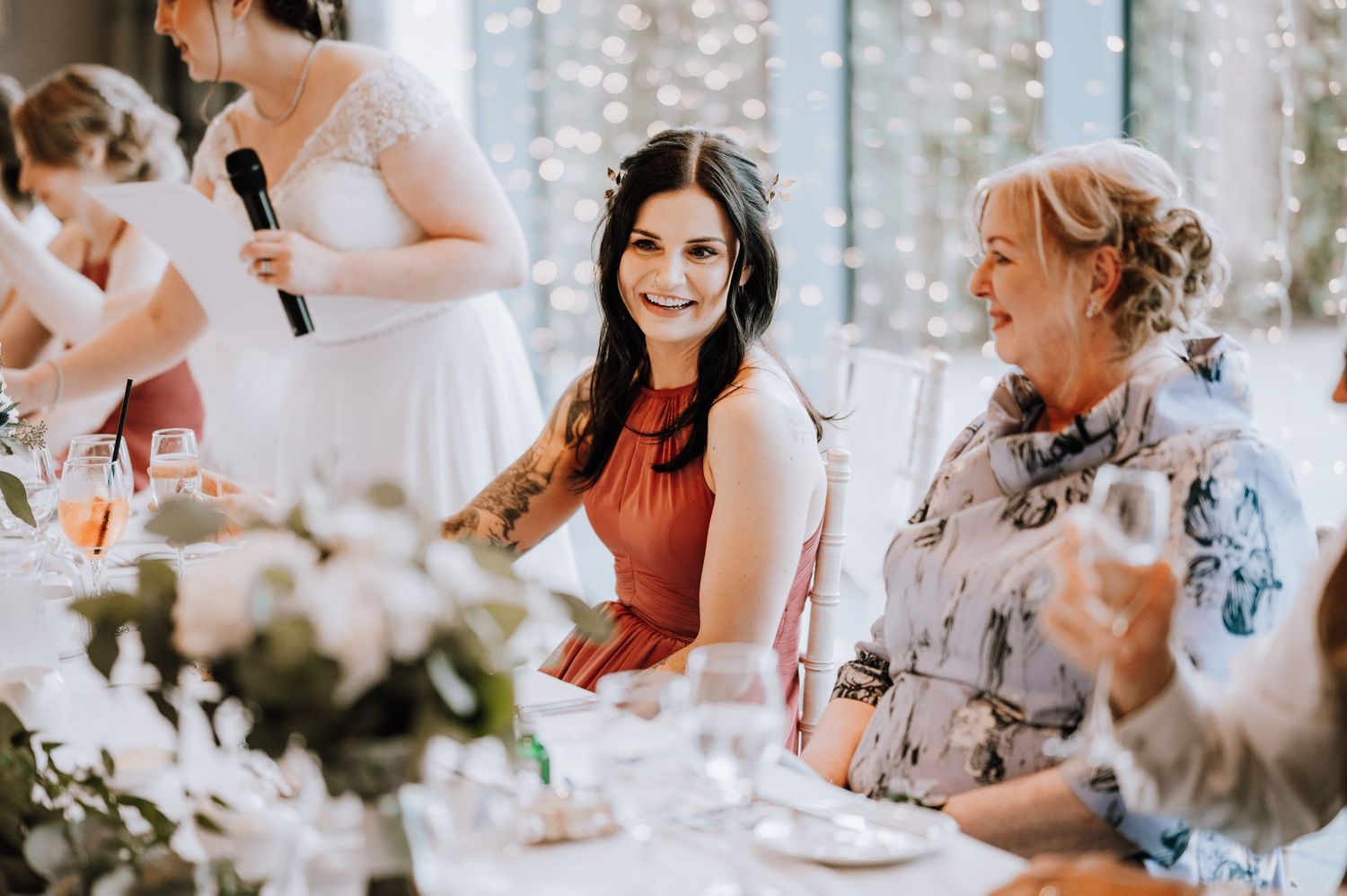 Guests enjoying conversations at a wedding reception with floral decorations Meldrum House Wedding Photography.