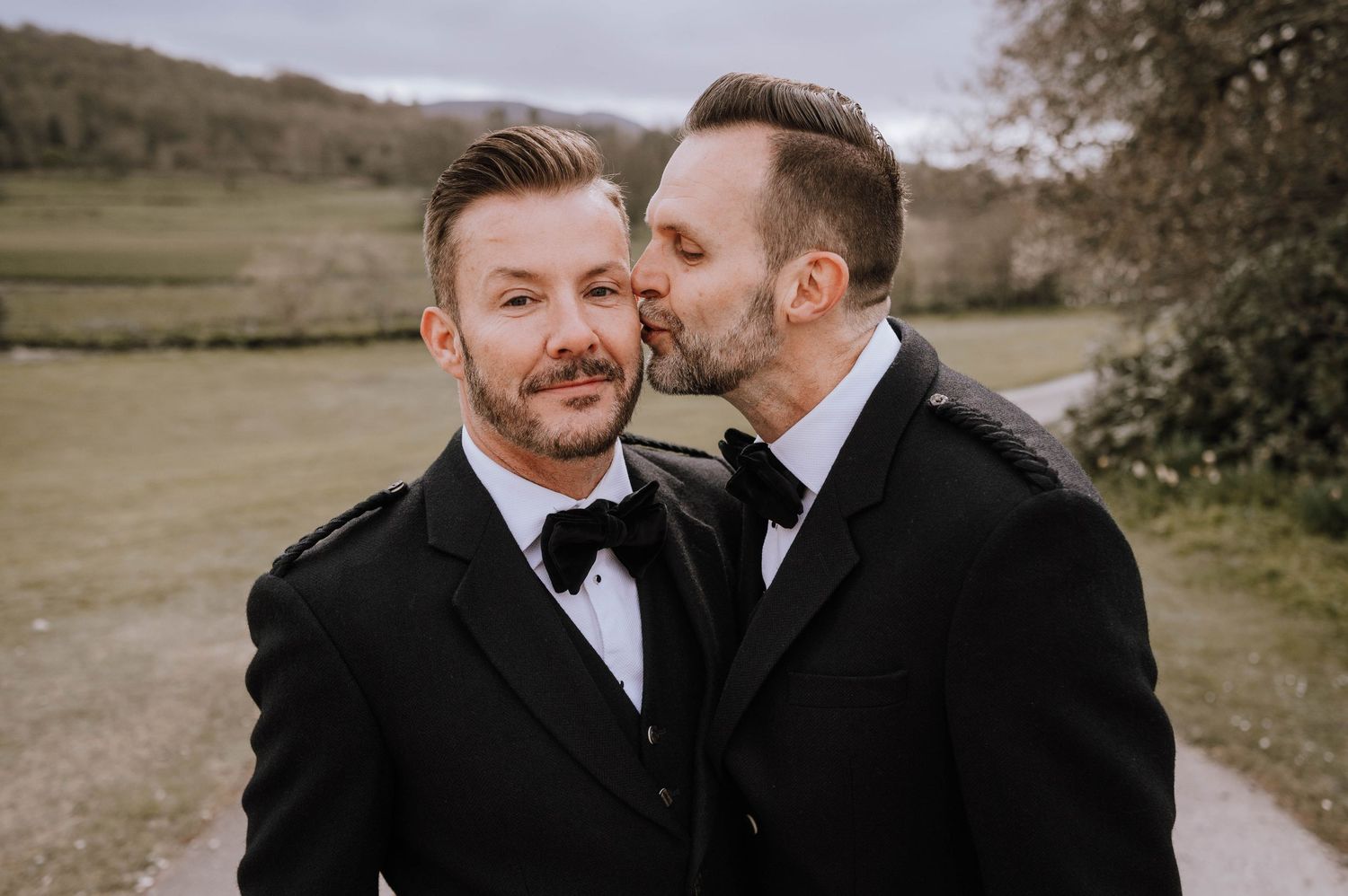 Logie House Wedding Photography. A couple in formal attire embraces during an outdoor wedding photoshoot.