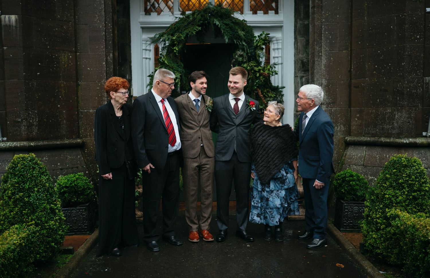 Group gathered outside a dark stone church entrance during an event.