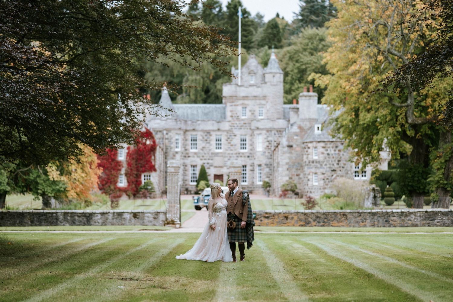 Historic stone castle building with beautiful landscaping and grounds on an autumn day.