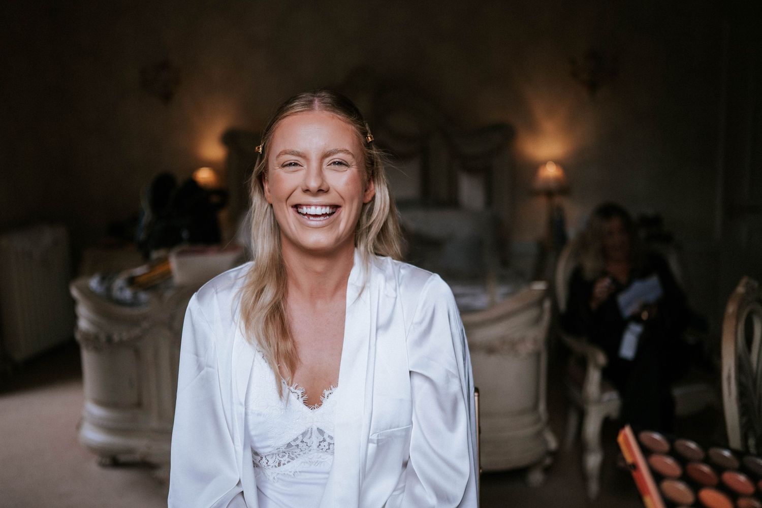 A candid moment shows a joyful expression in white attire against a warmly lit interior background.