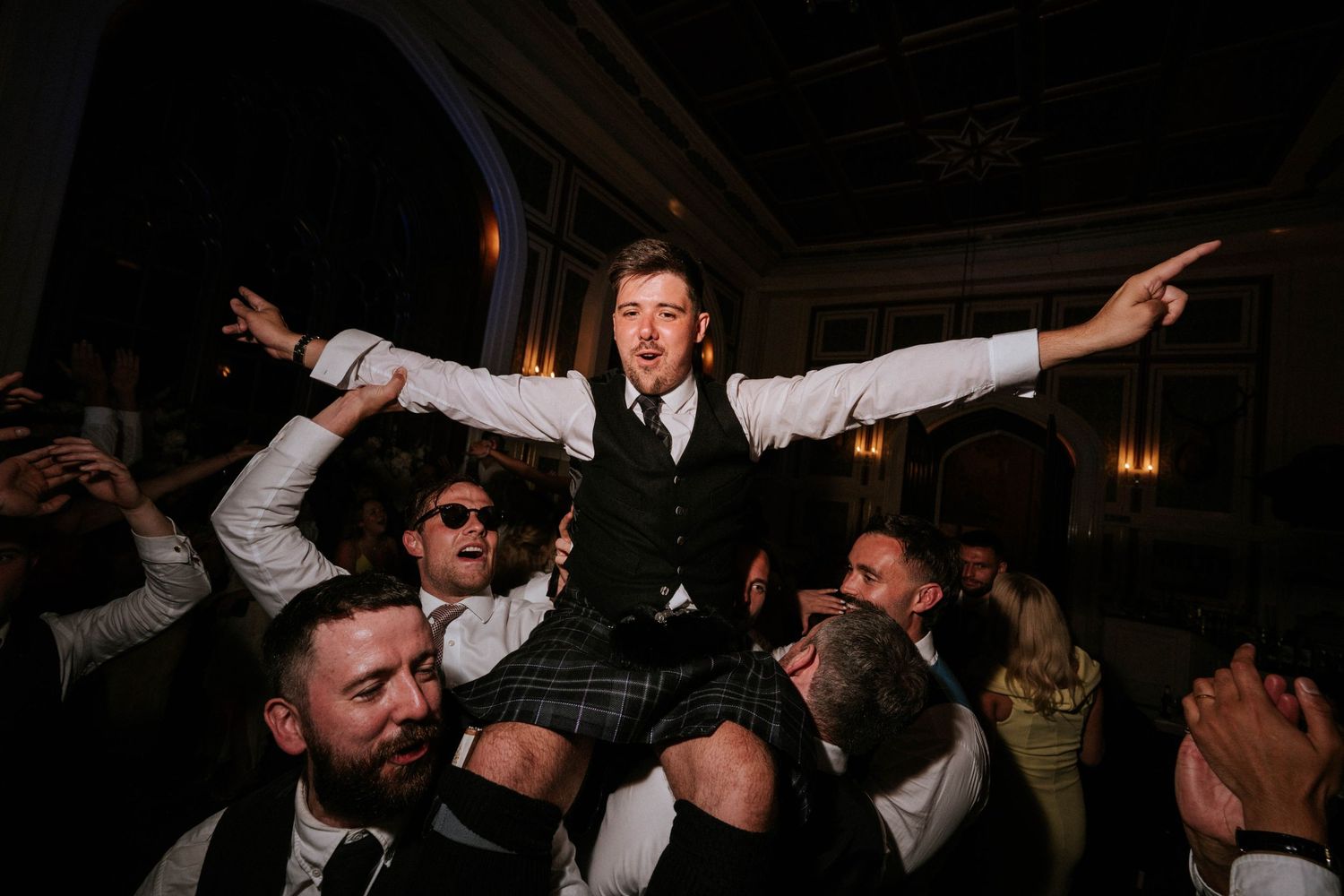 Lively dance party scene with guests celebrating at a wedding reception.