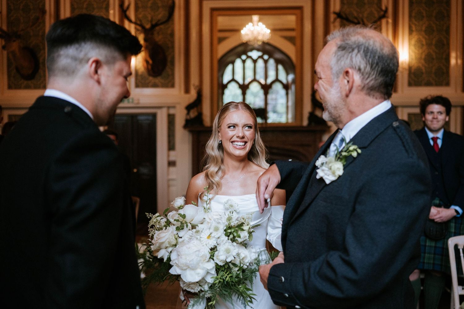 Wedding ceremony taking place in an ornate historic venue with traditional decor.