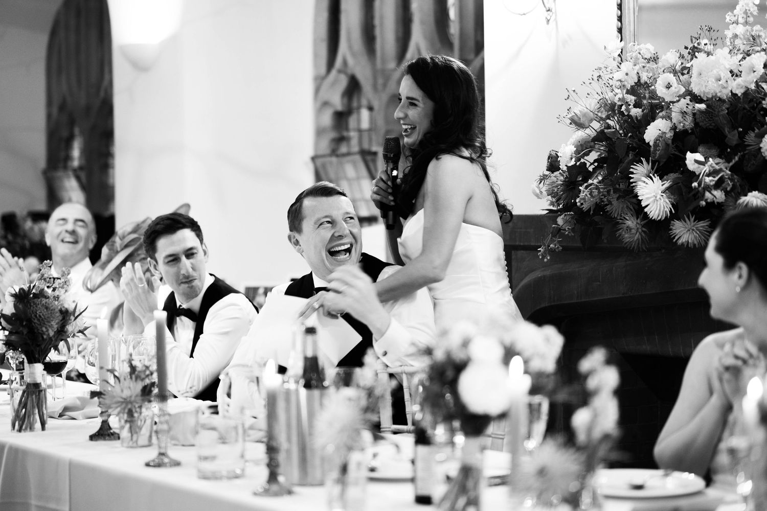 Black and white candid shots of wedding reception guests enjoying speeches and laughter.