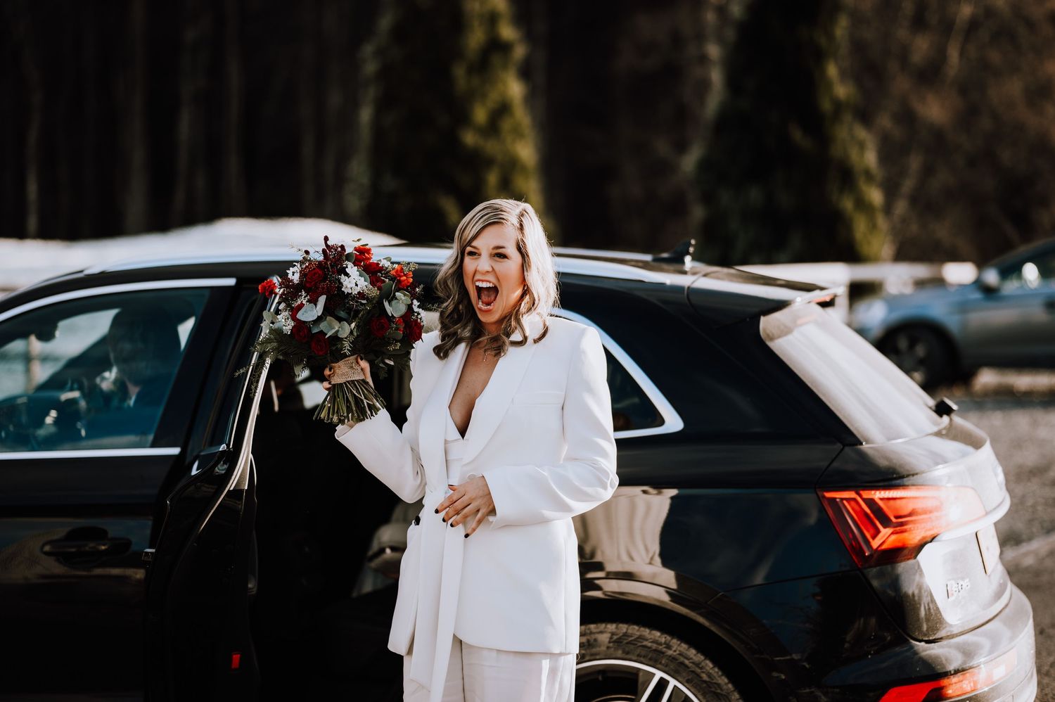 Same Sex Wedding Photography. A winter wedding party poses outdoors in black and white attire against snowy backdrop.