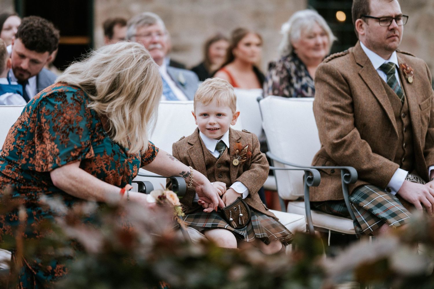 Wedding guests seated outdoors enjoying the ceremony in casual fall attire.
