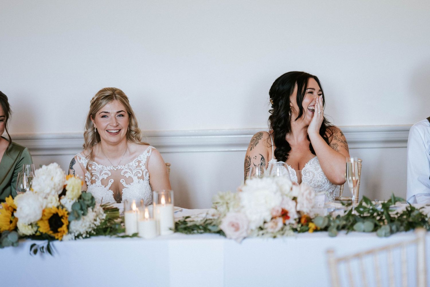 Fasque Castle Wedding Photography. Wedding reception table decorated with floral arrangements and place settings in an elegant white room.