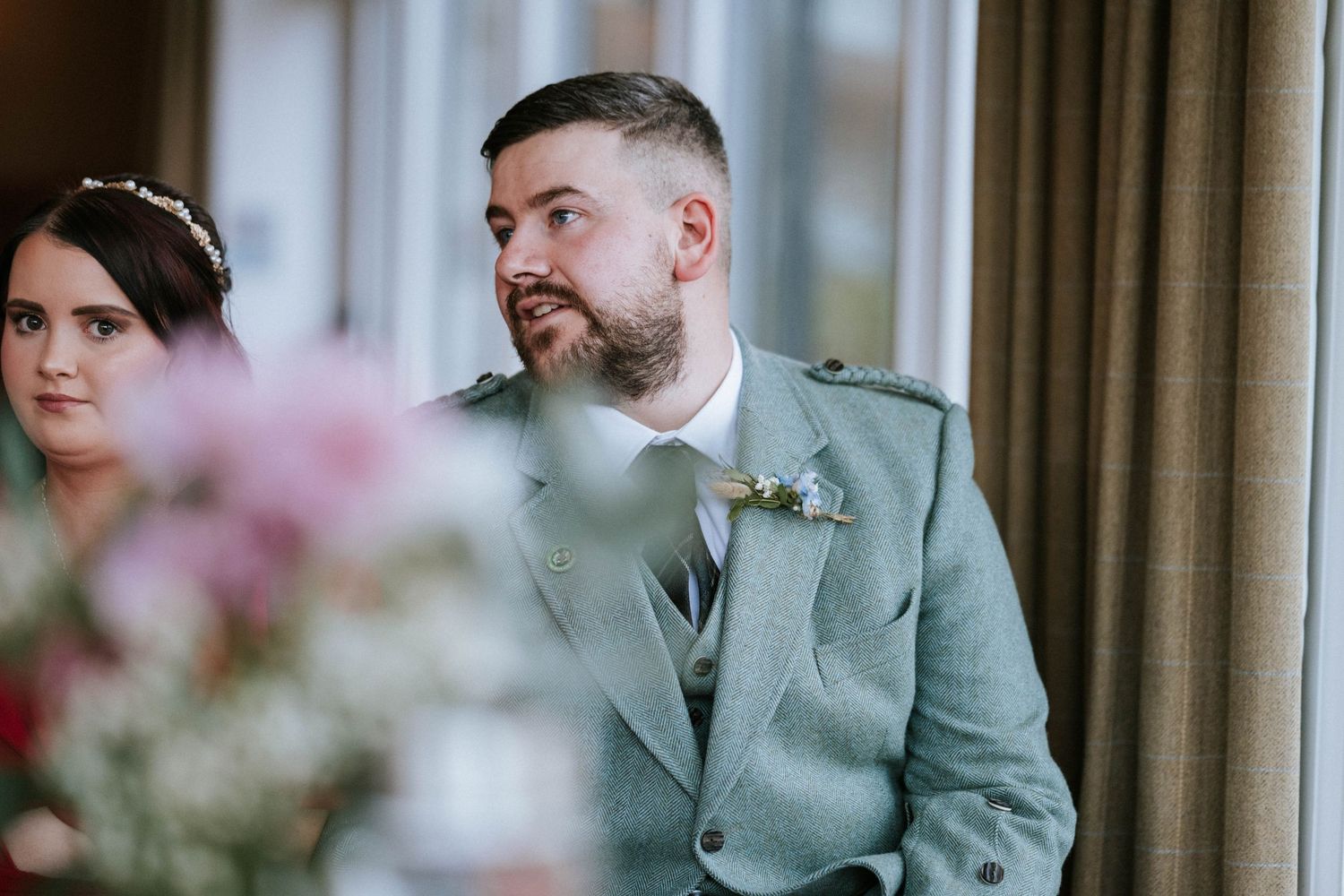 Wedding party members gathered in elegant venue with soft lighting and formal attire.