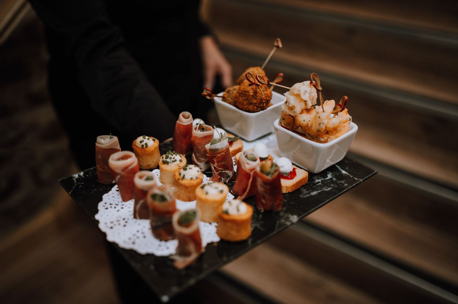 Catering tray of gourmet appetizers and canapes arranged on decorative serving platters.