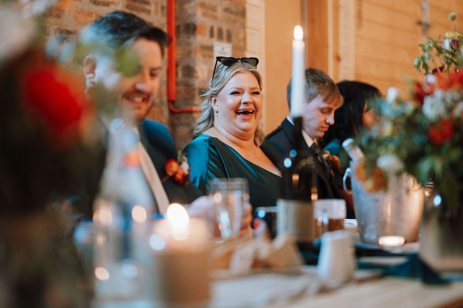 Wedding reception scene with guests celebrating at decorated dinner table.