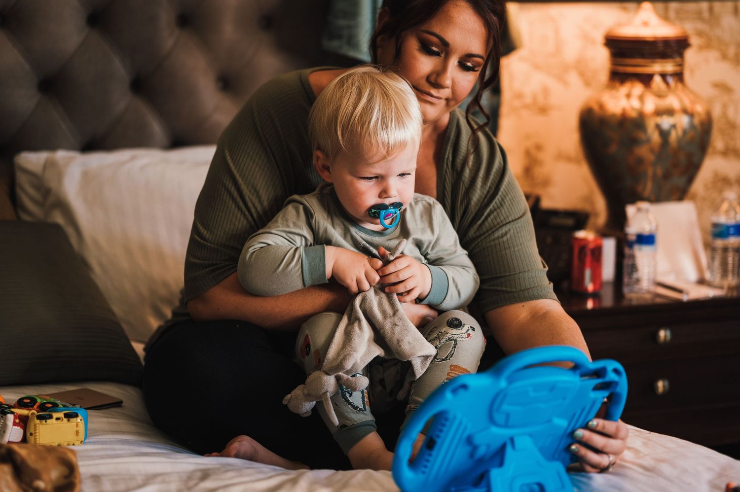 A tender moment shared between parent and child sitting together on a couch with toys nearby.
