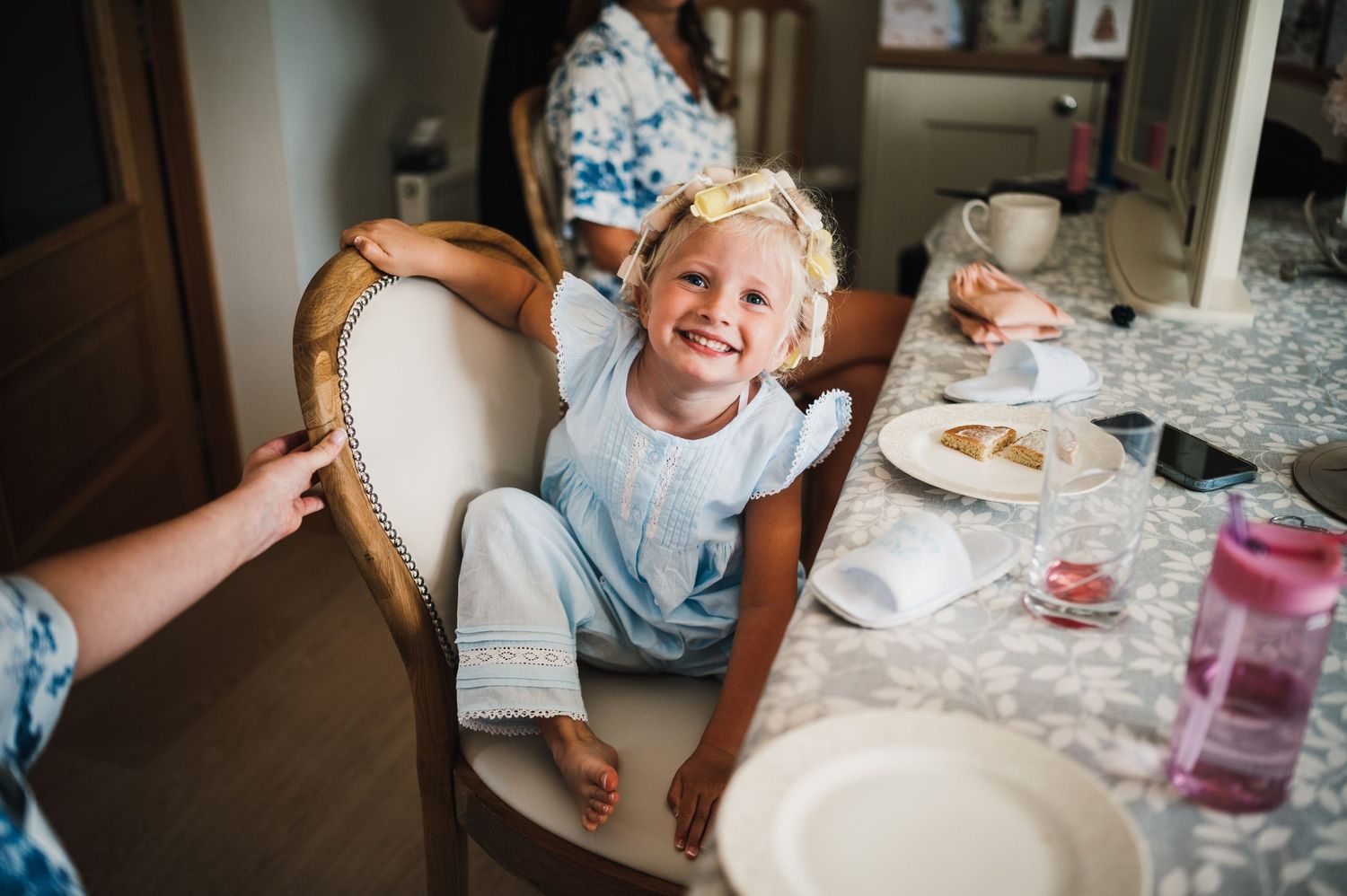 Candid moment at a bridal preparation breakfast table with china and treats.
