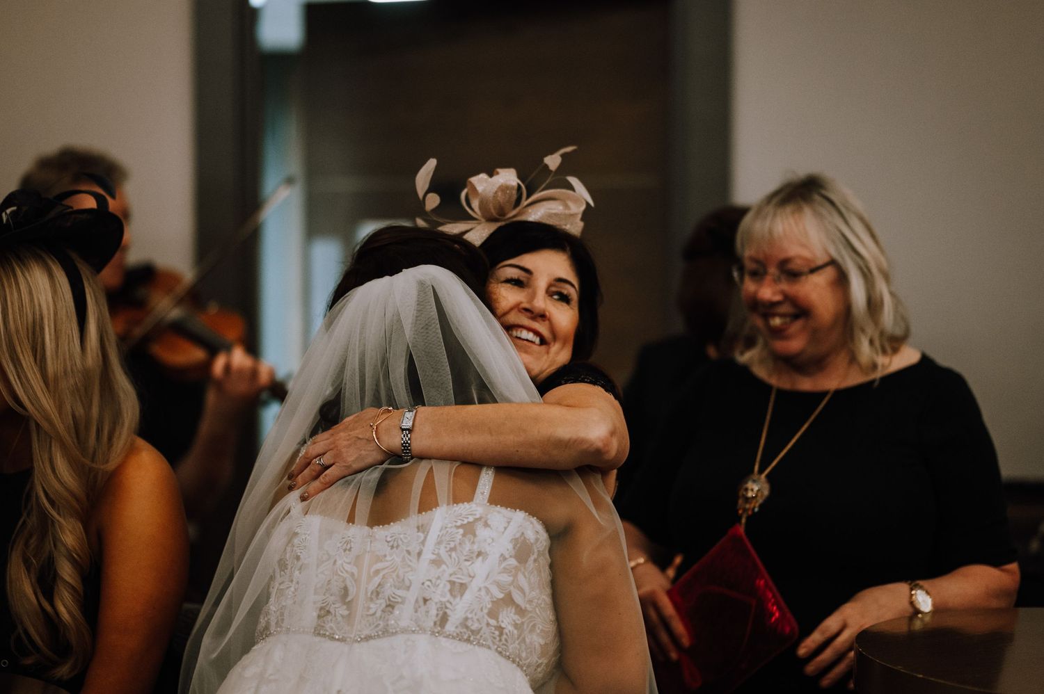 Celebratory moment captured as guests share hugs and laughter at a formal event.