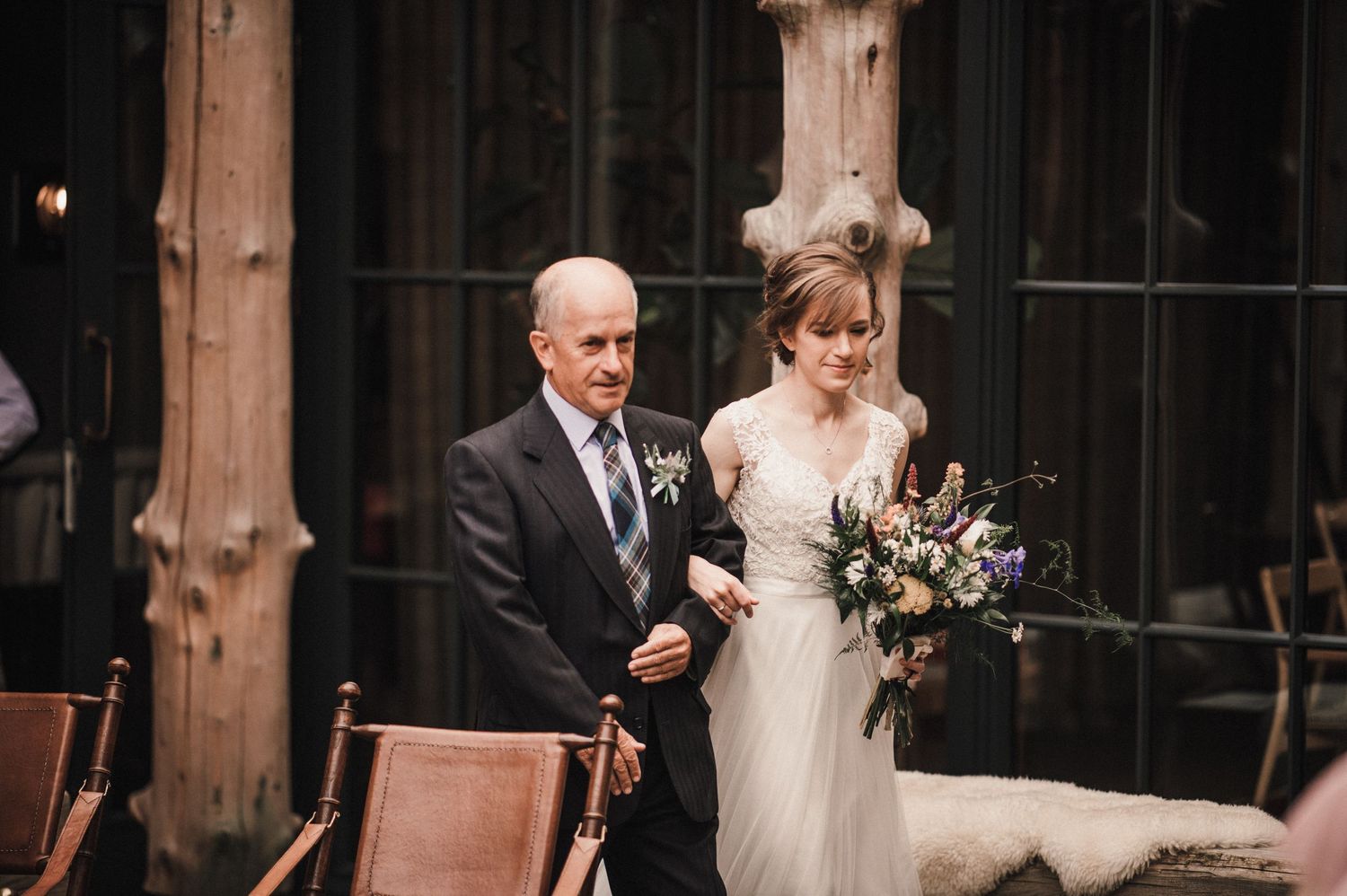 An elegant wedding ceremony moment captured in front of wooden beams and chairs.