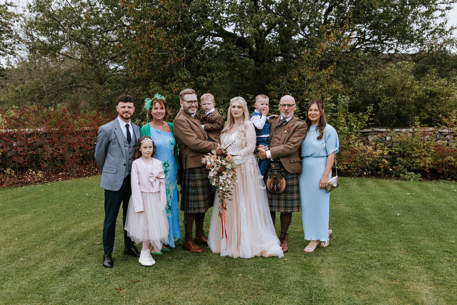 Extended family portrait at Scottish wedding with mix of traditional and modern attire.