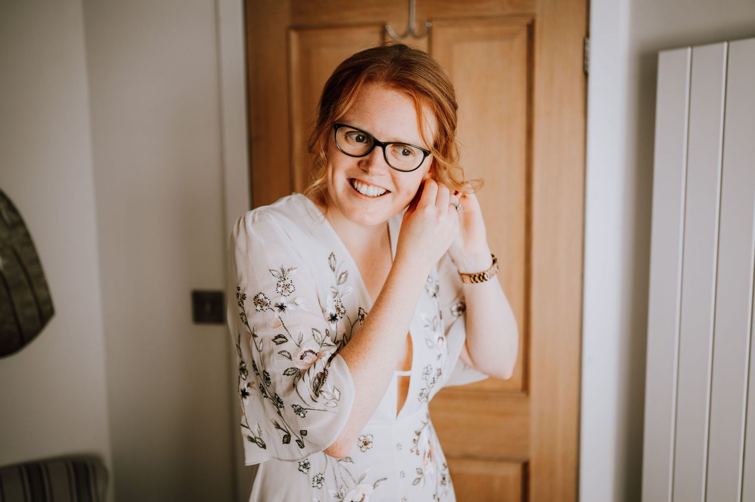 Natural light portrait of a person in a floral robe near a wooden door.