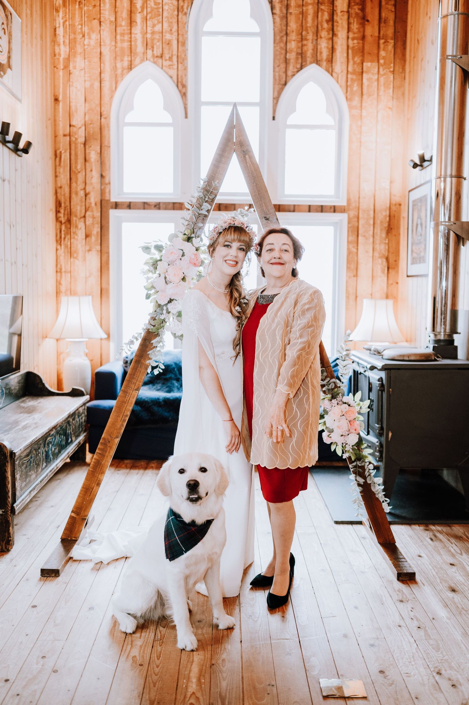 Elegant wedding portrait with white dog in rustic chapel setting.