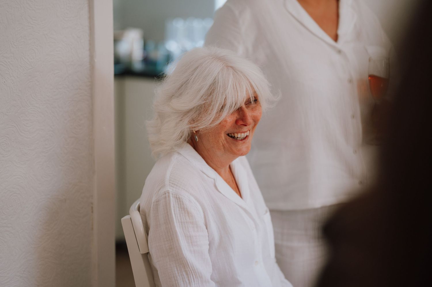 A candid moment of joy and laughter captured in a bright indoor setting.