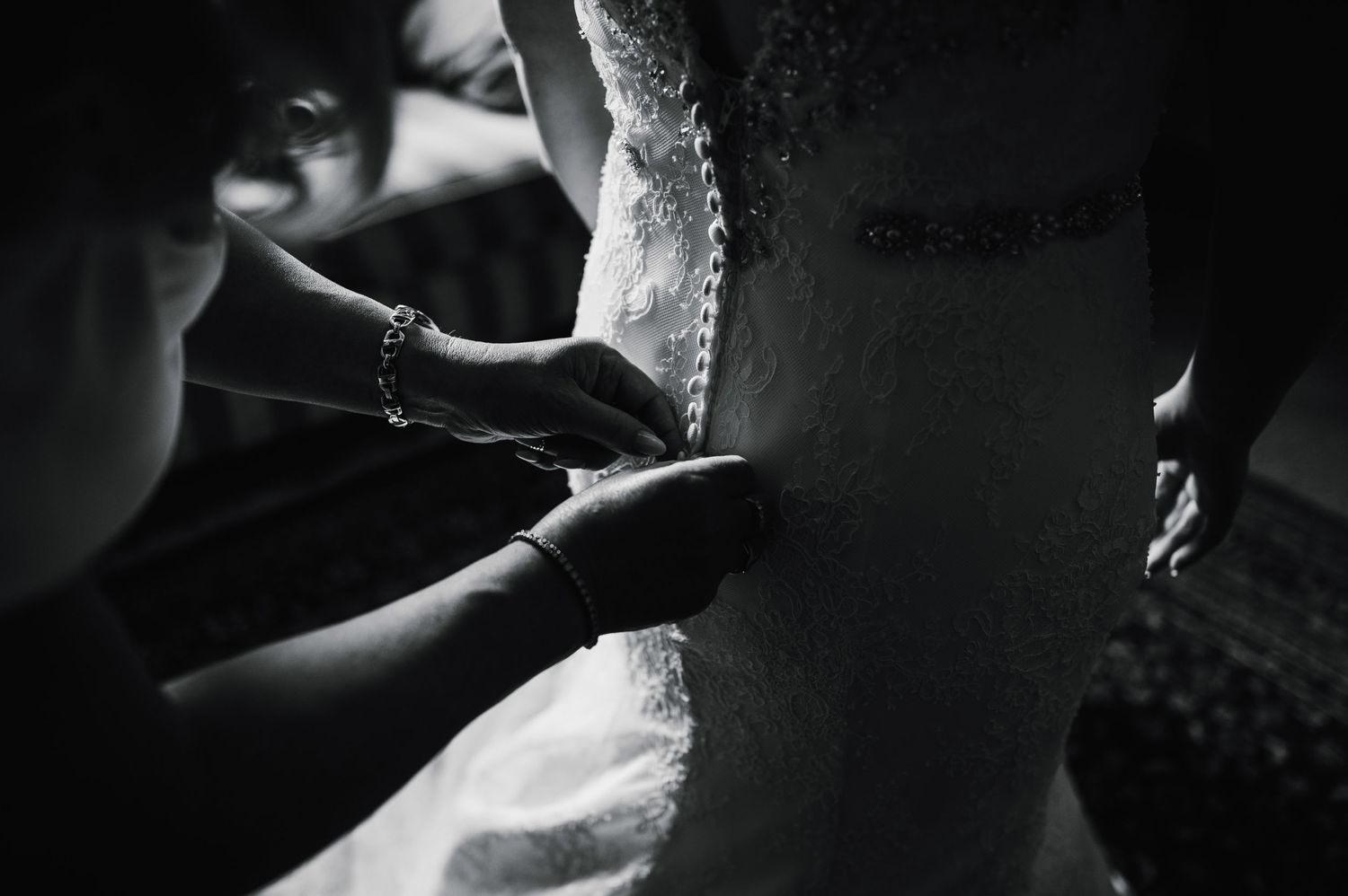 Close-up black and white shot of dress being adjusted.