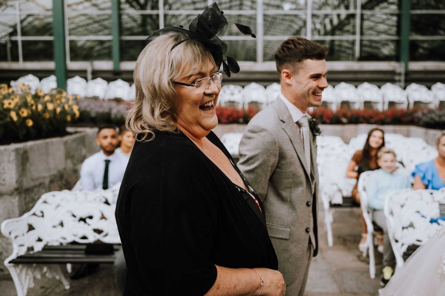 Wedding guests share a candid laugh during an intimate outdoor ceremony.