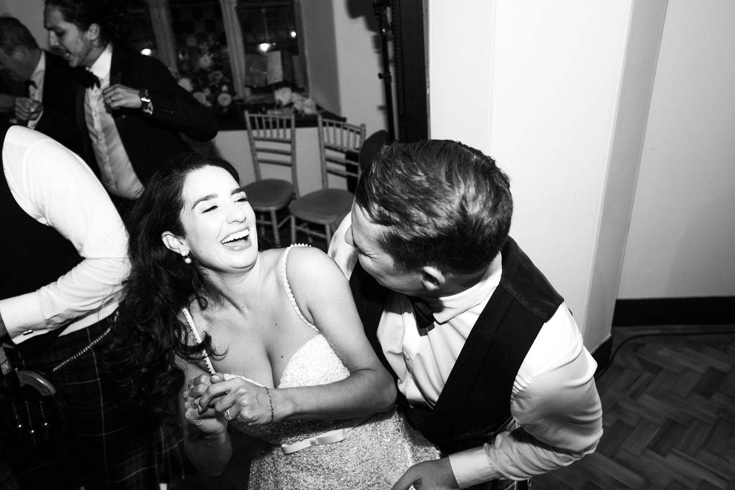 Black and white photos capture joyful dancing moments at a wedding reception.