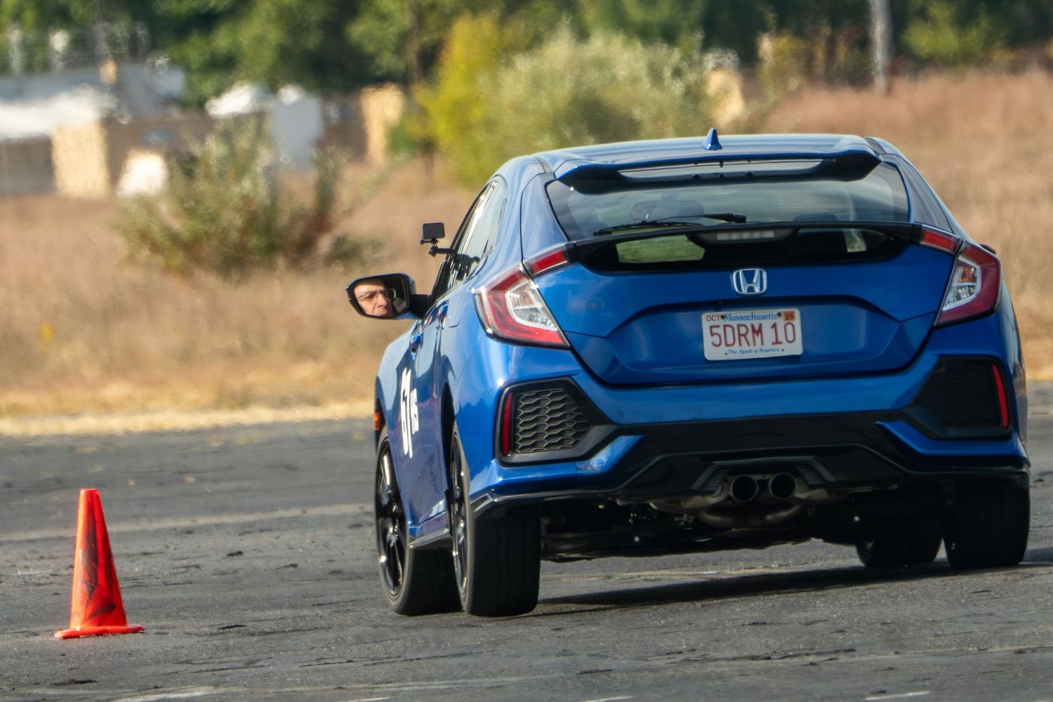 Honda Civic Type R performing a high-speed turn on an autocross track with dust trailing behind.