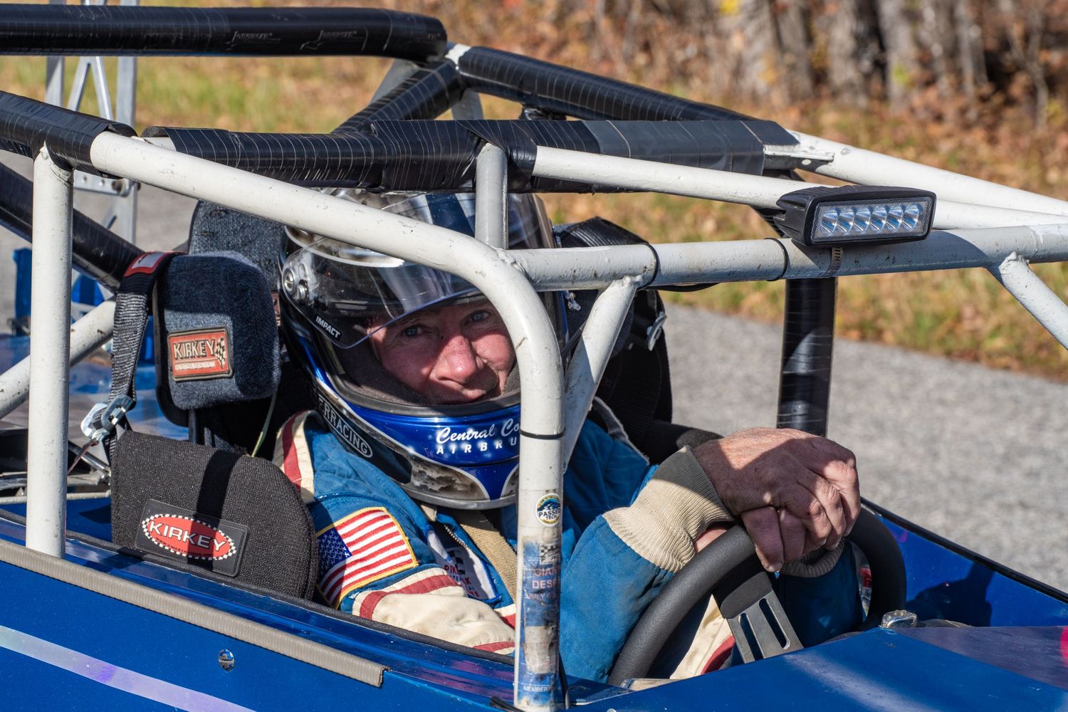 A racing vehicle with safety equipment competes on a mountain course.