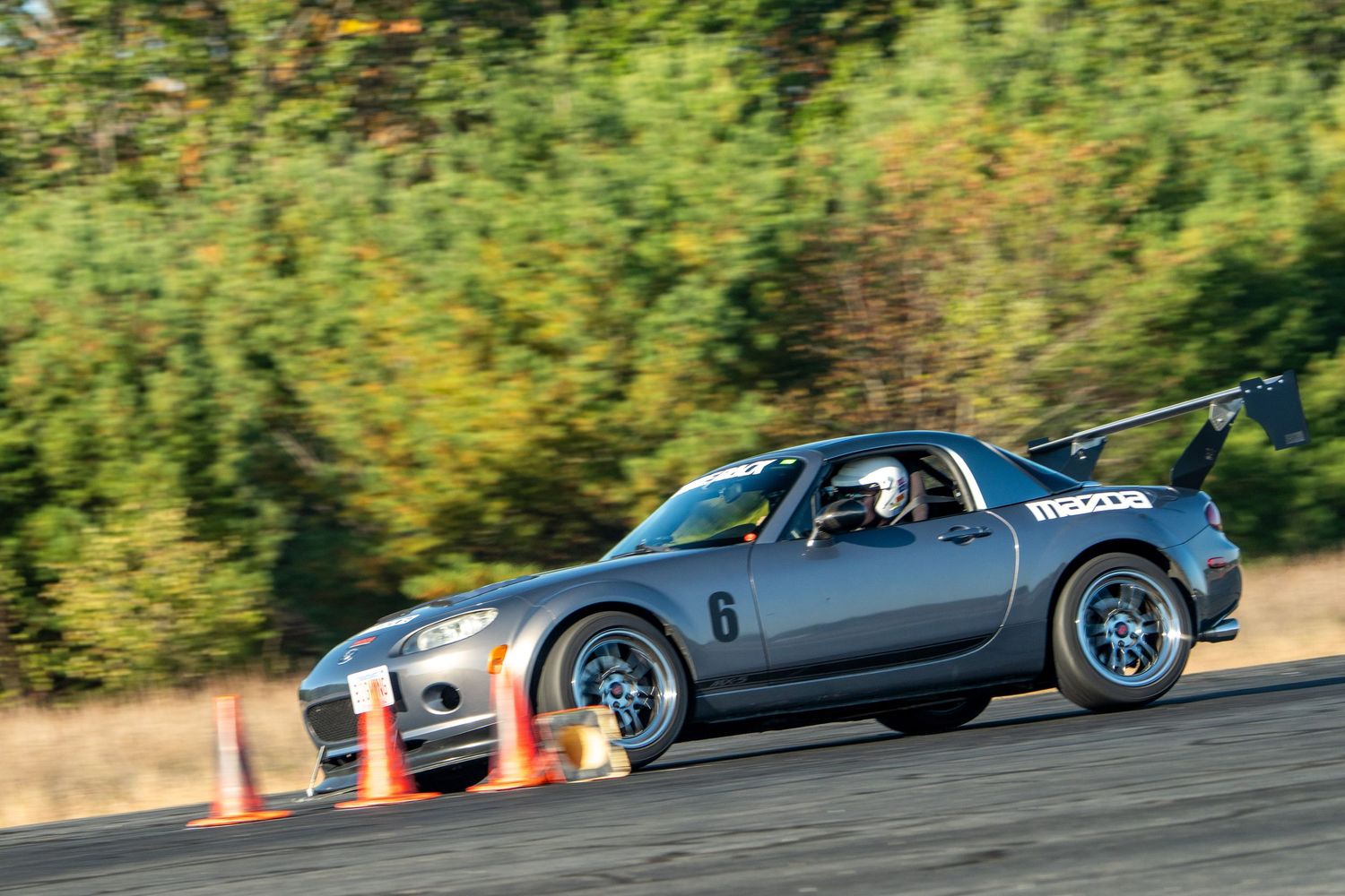 Performance cars racing through a winding track during an autocross event.