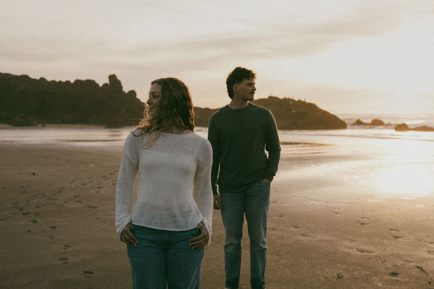 Oregon Coast sunset couples photoshoot couple standing together for cute editorial pose together.