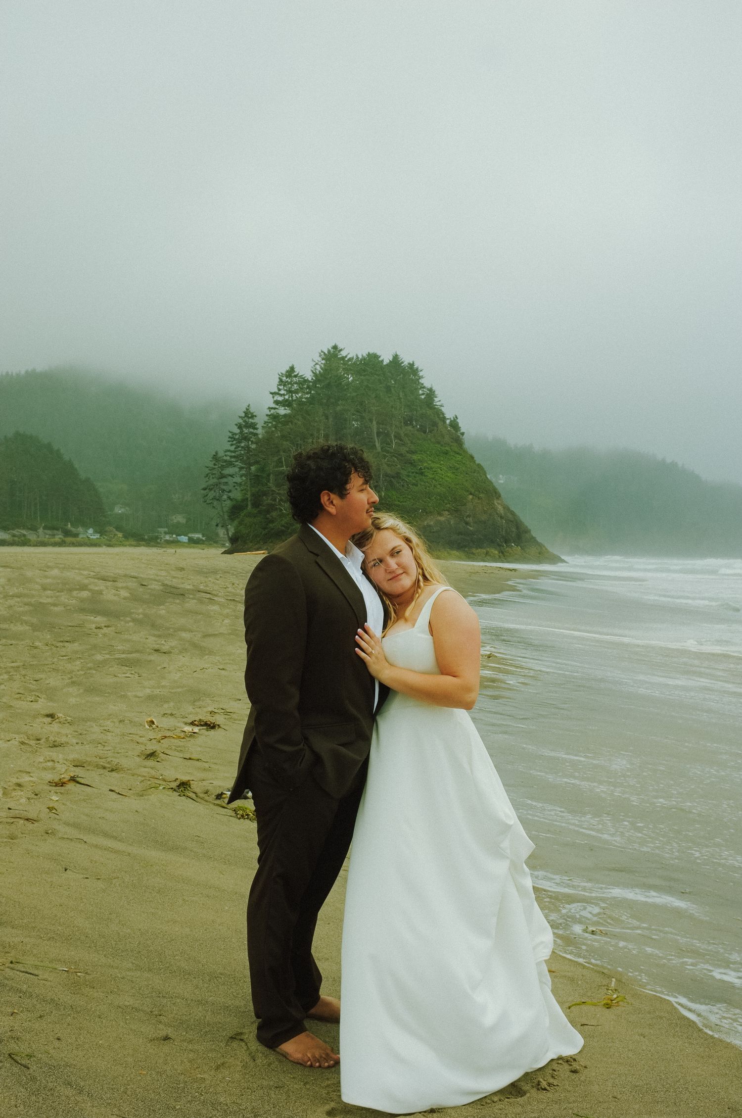 Oregon wedding photographer captures couple at Oregon coast Wedding with Fujifilm x100 for dreamy shot embracing eachother.