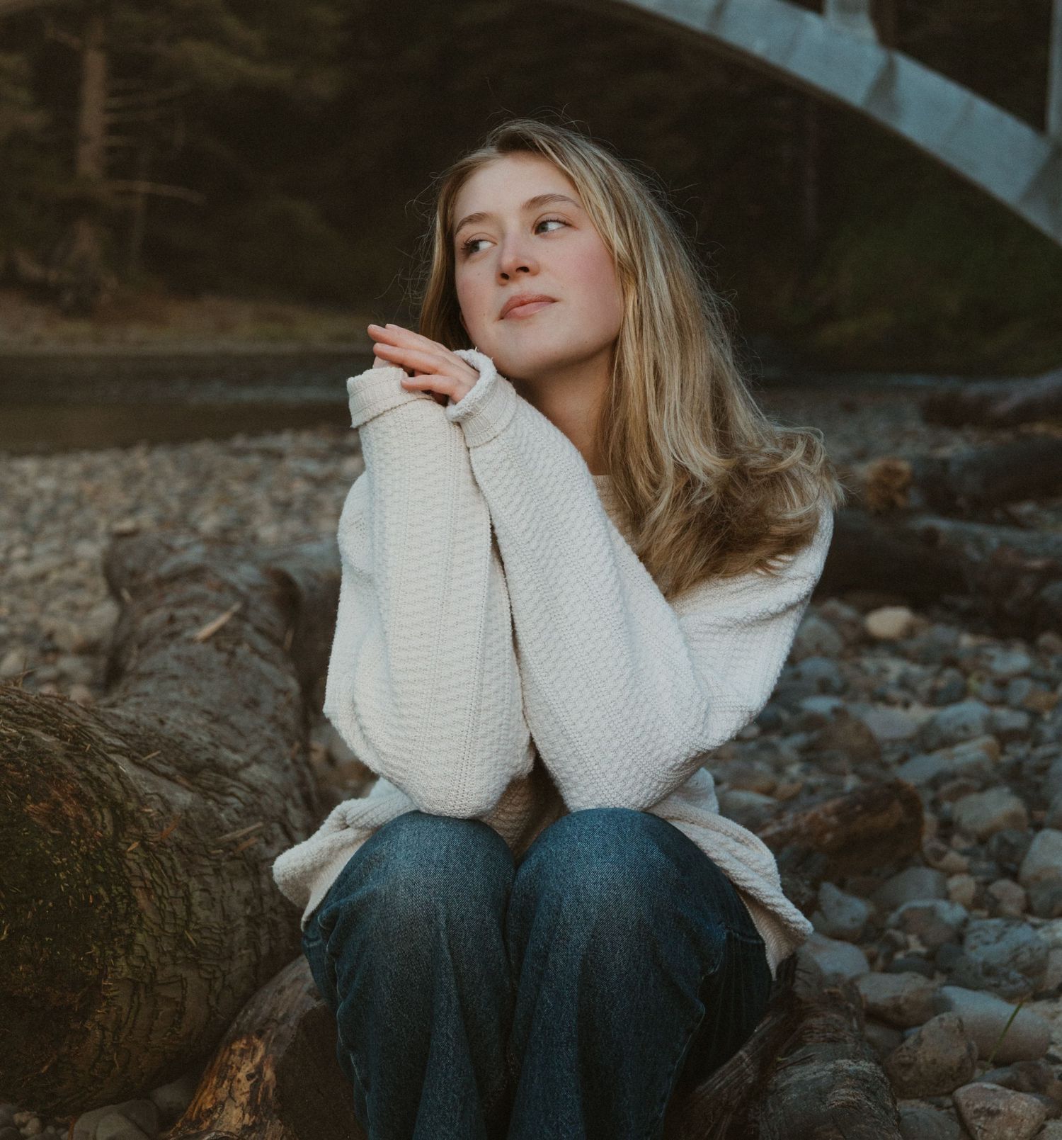 PNW Model Maddie posing on rocky beach with bridge in the back during golden hour during her editorial session with Andi Rane Photo