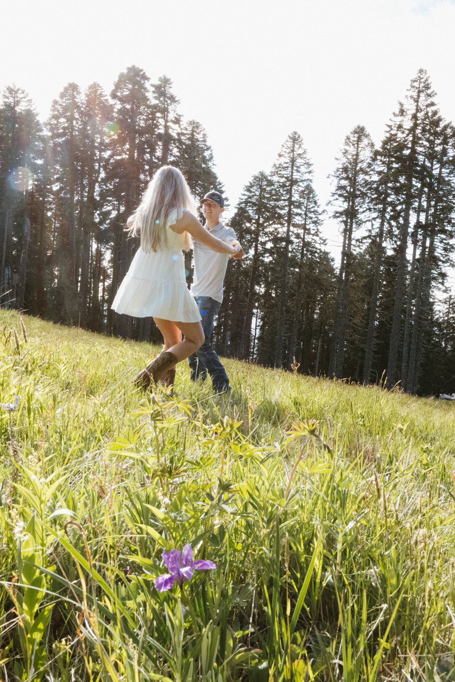 Wildflower field couples session in Oregon playing ring around the rosie.