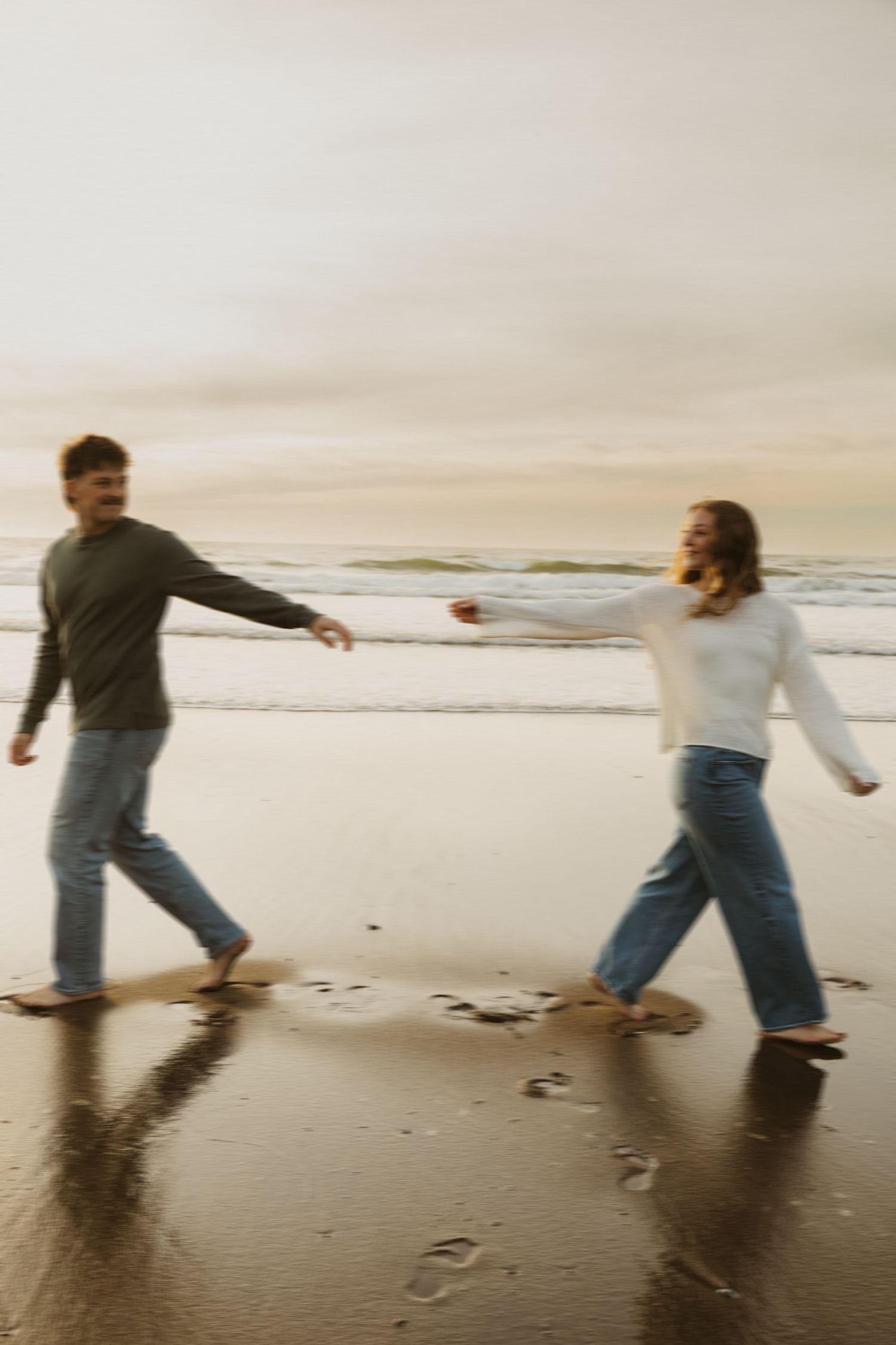 Storytelling couples photoshoot on the oregon coast with Anna and Carson reaching for eachother as they walk away from each other.