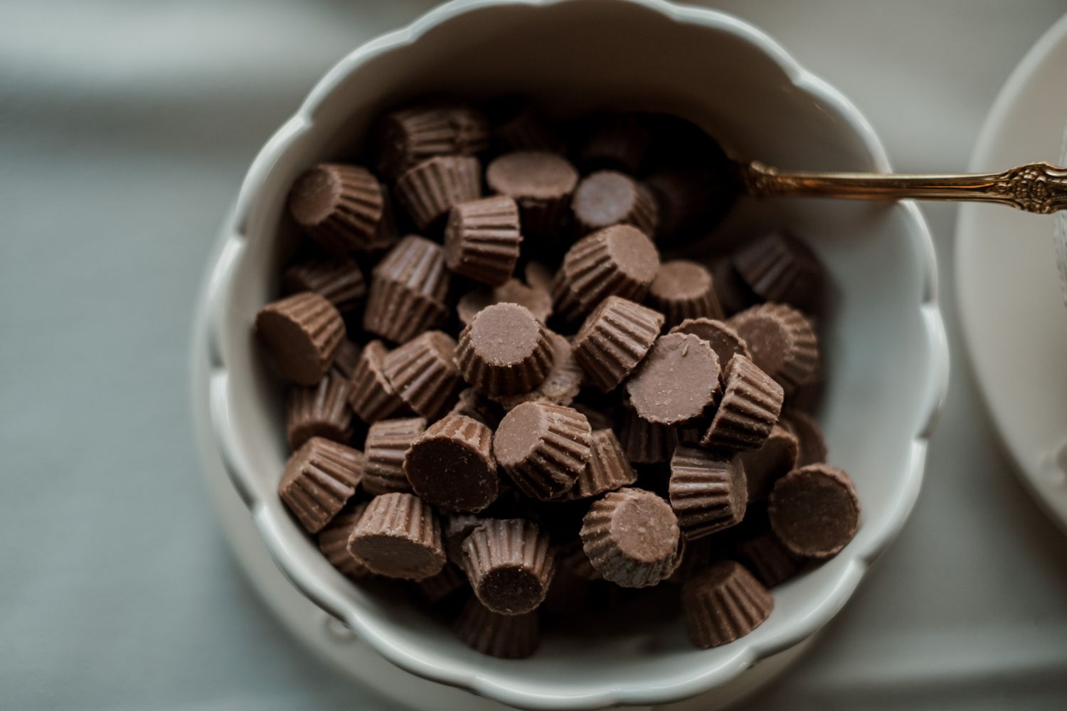 Bowl of chocolate candies arranged on white tablecloth at wedding reception.