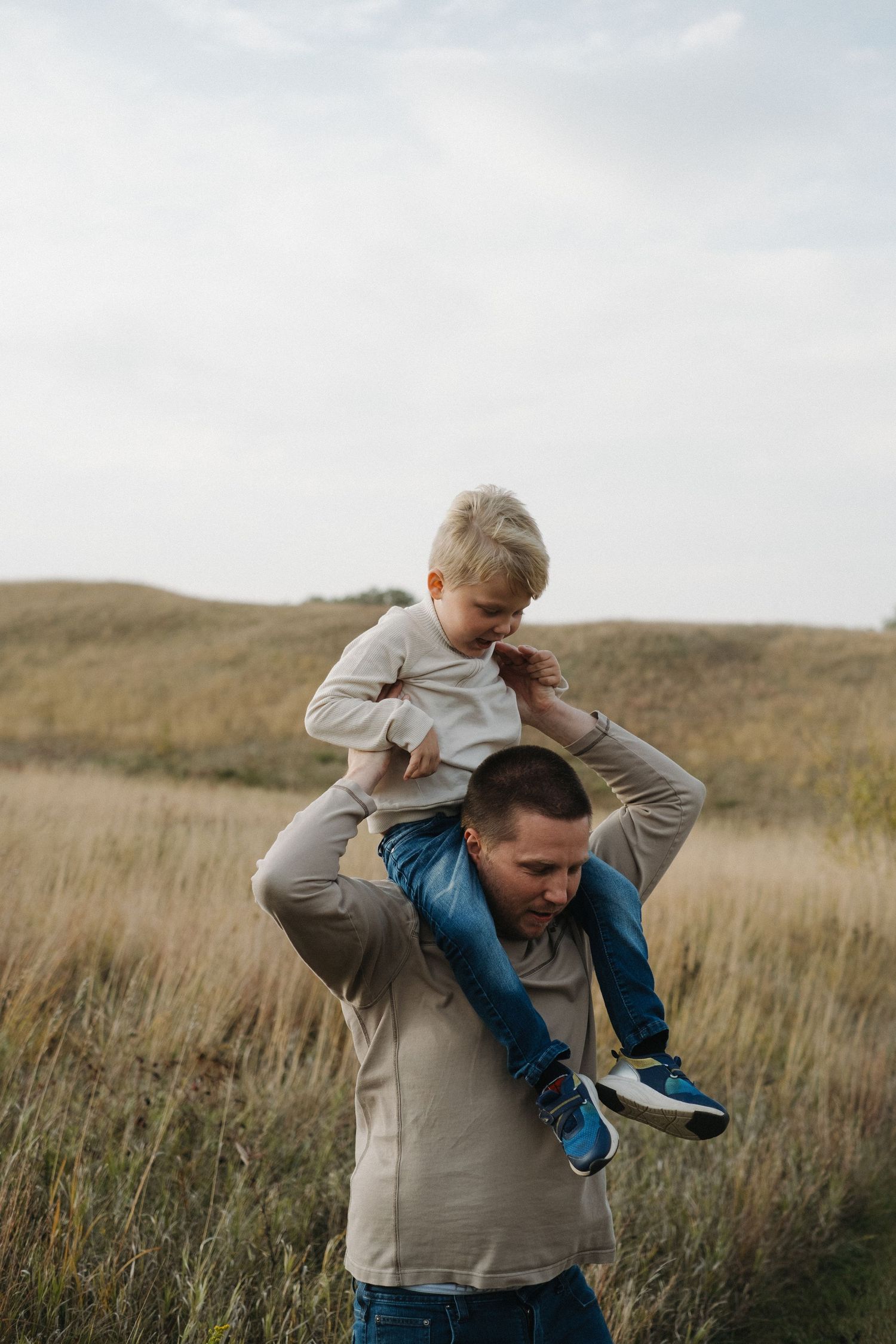 A playful piggyback ride moment captured in a golden field.