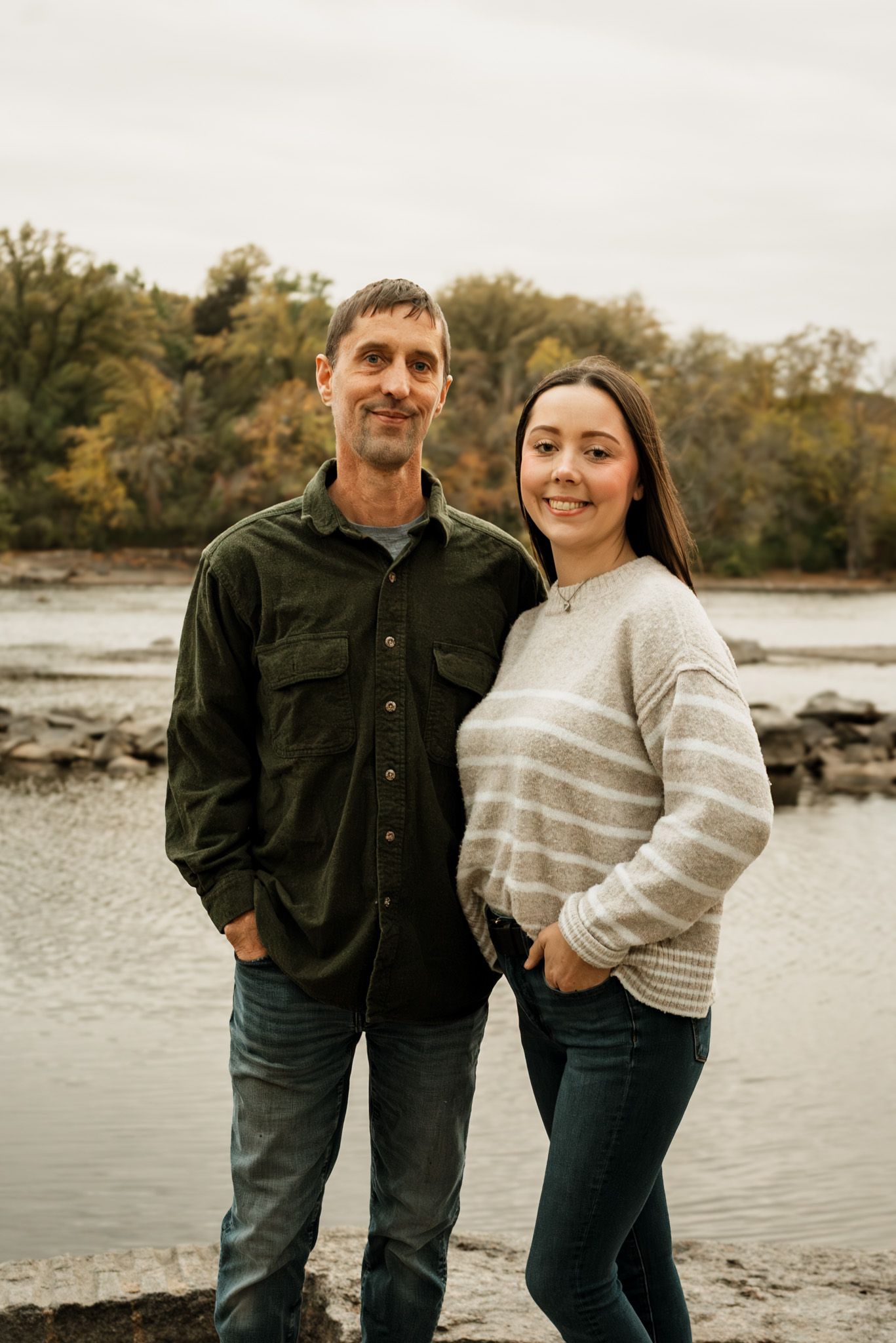 A couple shares playful moments together during a waterfront photoshoot.