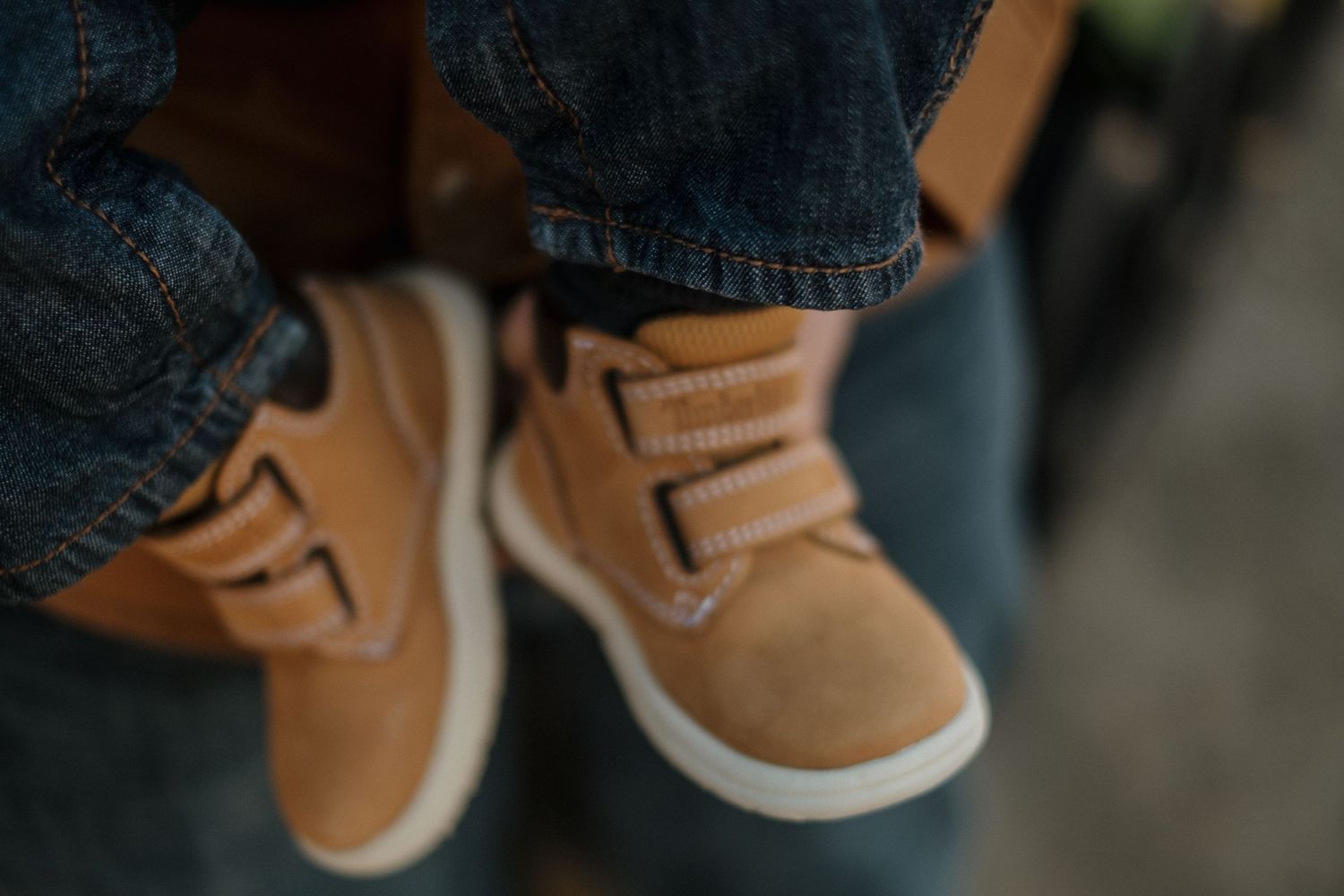 Close-up view of tan leather boots and blue jeans.