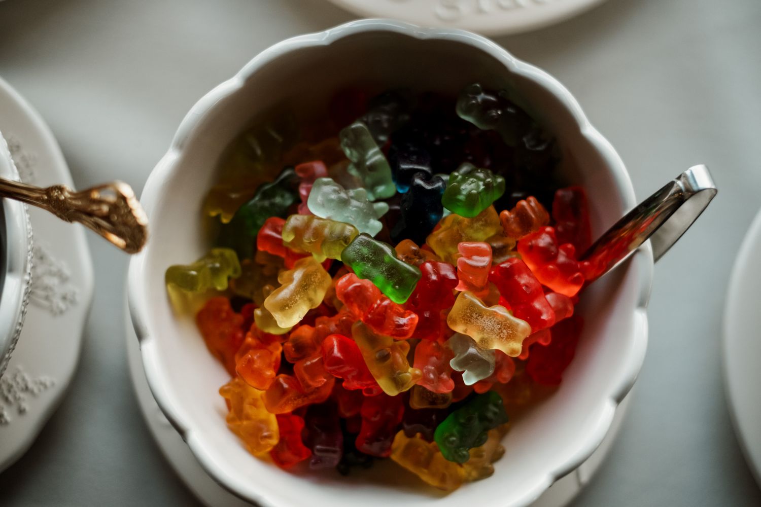 Colorful gummy bears displayed in white serving dish at wedding reception.