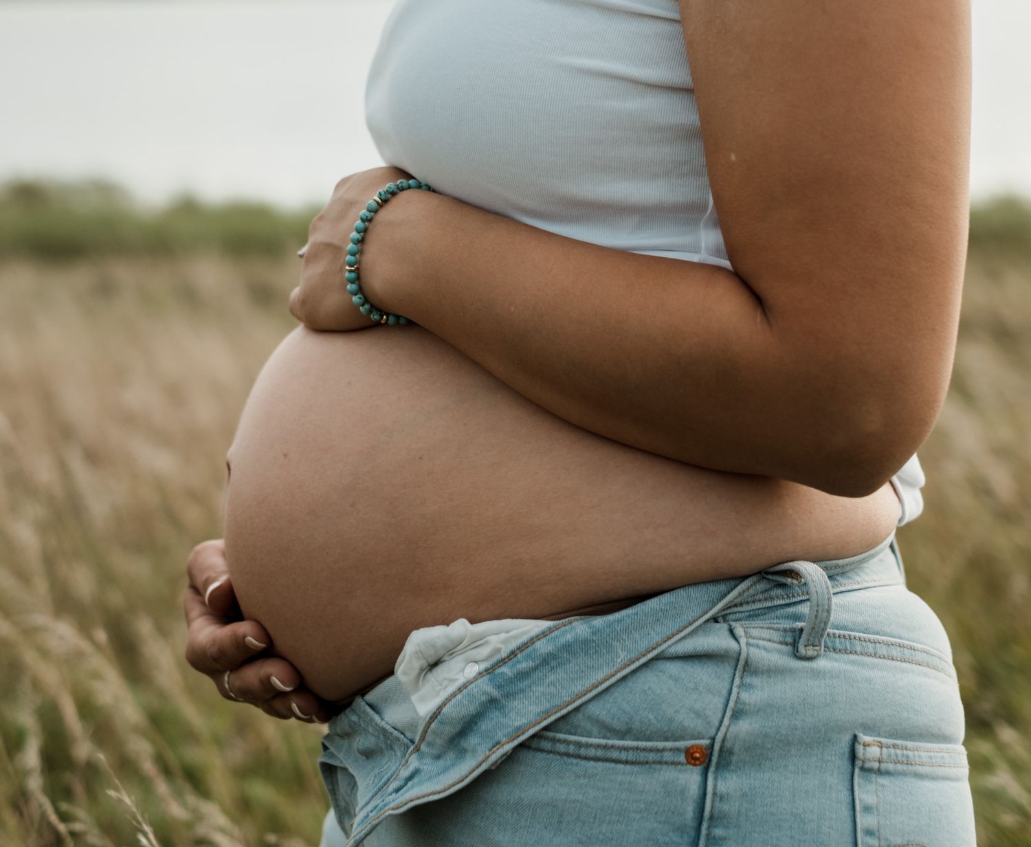 Side profile views of a pregnant belly against soft natural lighting.