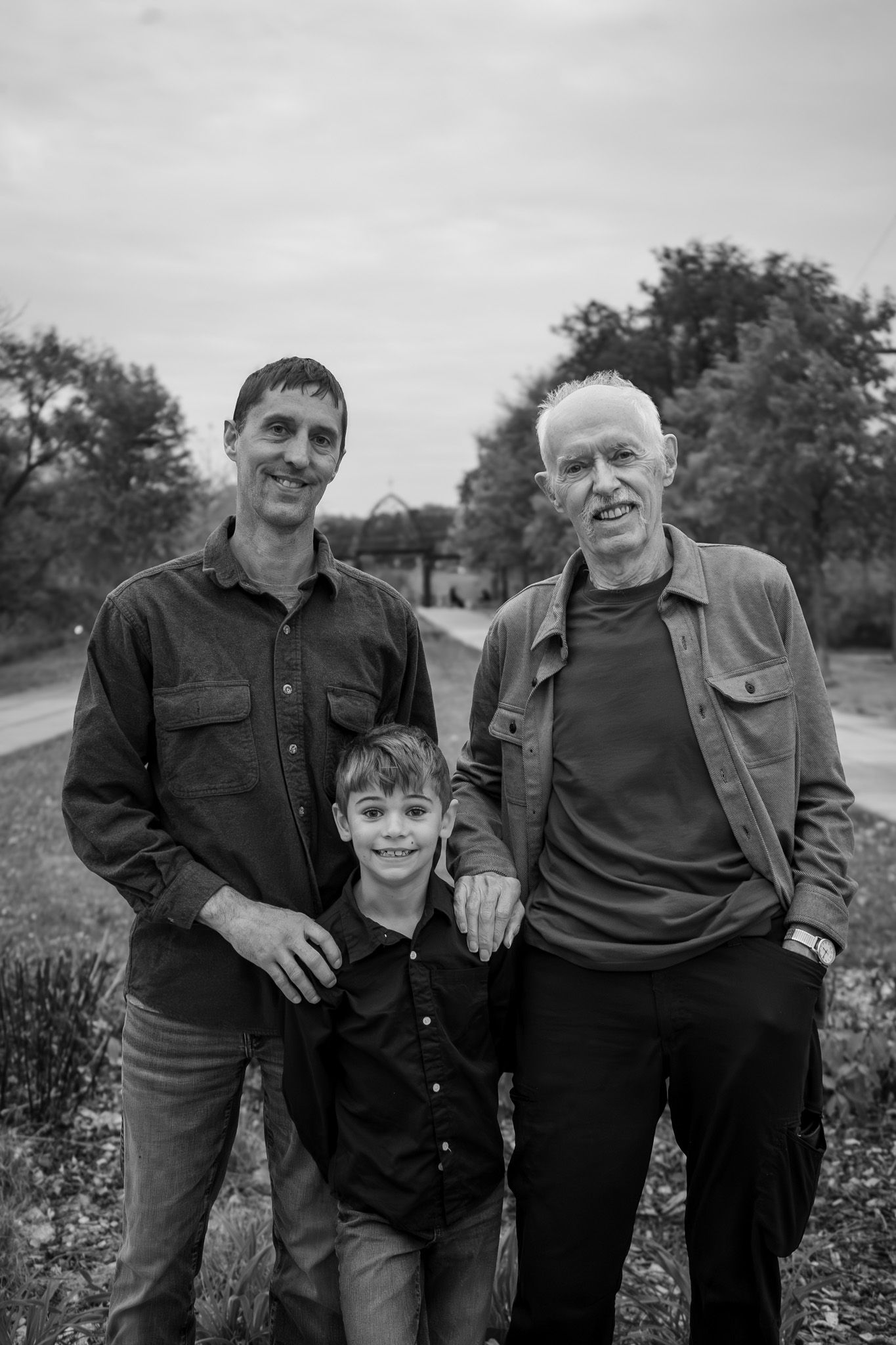 Black and white portrait of people sharing a joyful moment outdoors.
