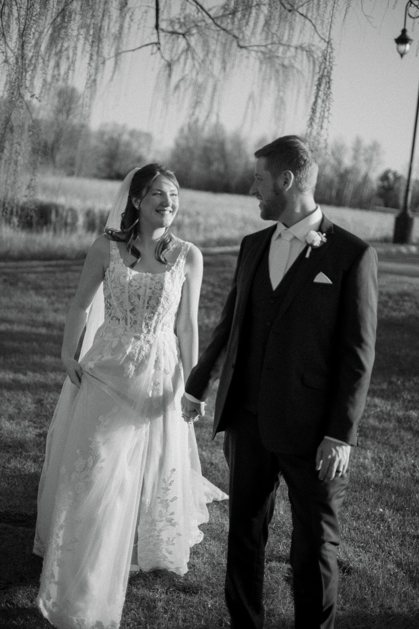 Black and white portrait of couple walking together during outdoor wedding session.